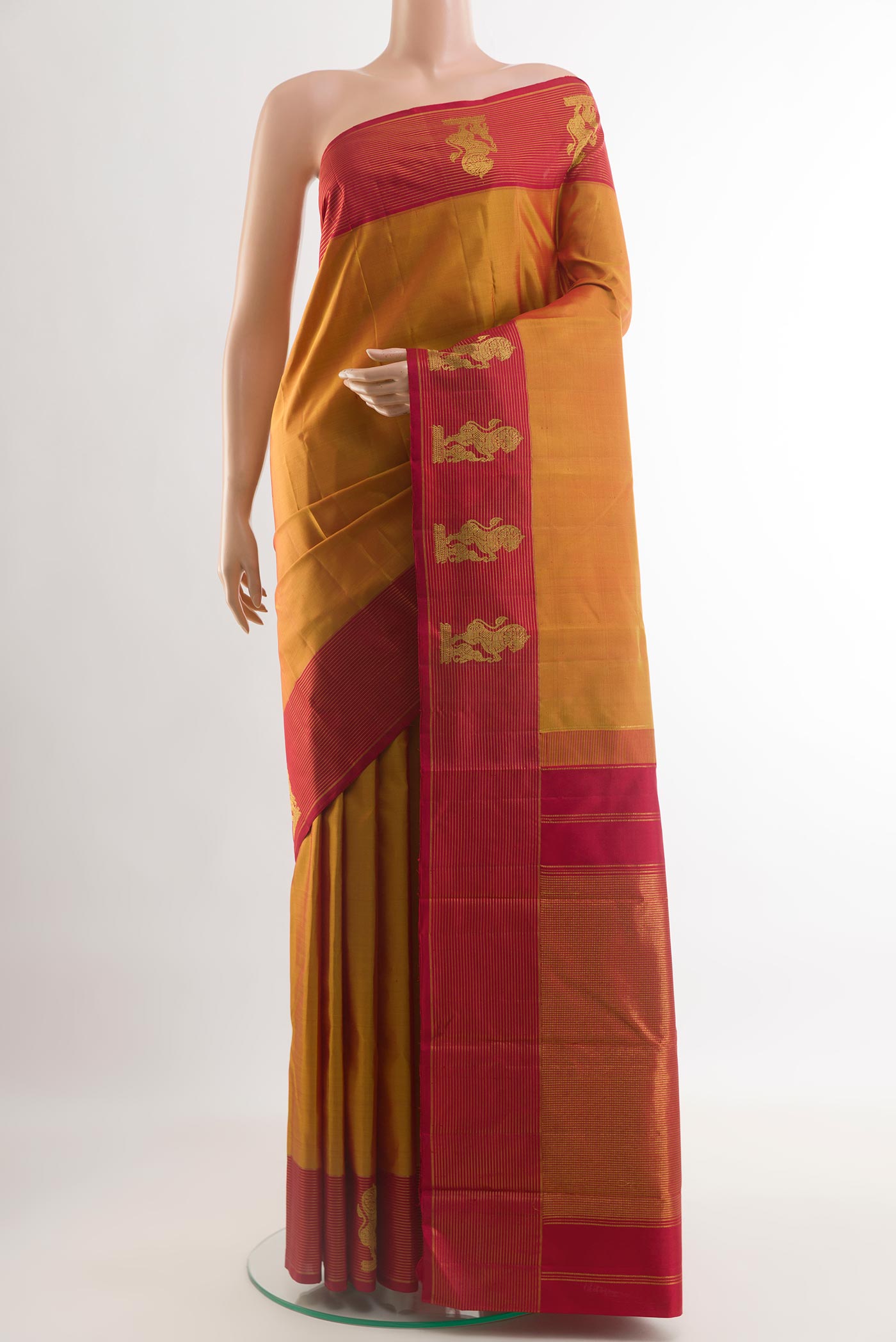 Mustard Kanchipuram Silk Saree with Zari Butta on the body and Zari Border.  displayed on a mannequin