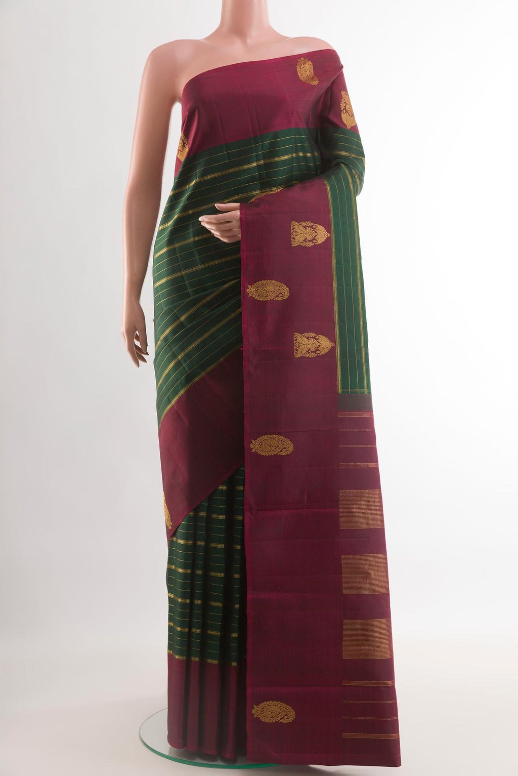 Bottle Green Kanjivaram Silk Saree with Stripes on the body and Zari Border.  displayed on a mannequin