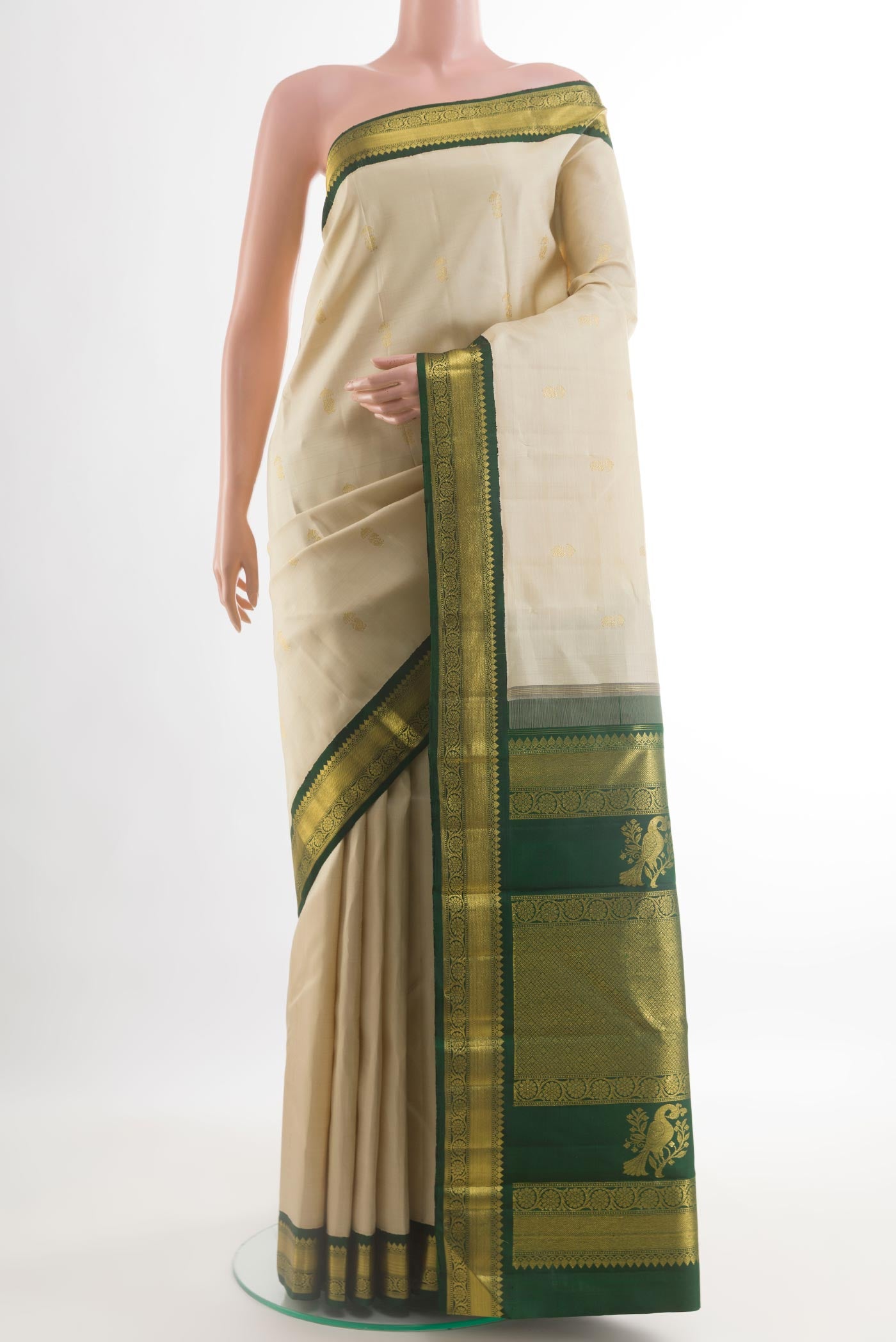 Off White Kanchipuram Silk Saree with Zari Butta on the body and Zari Border.  displayed on a mannequin