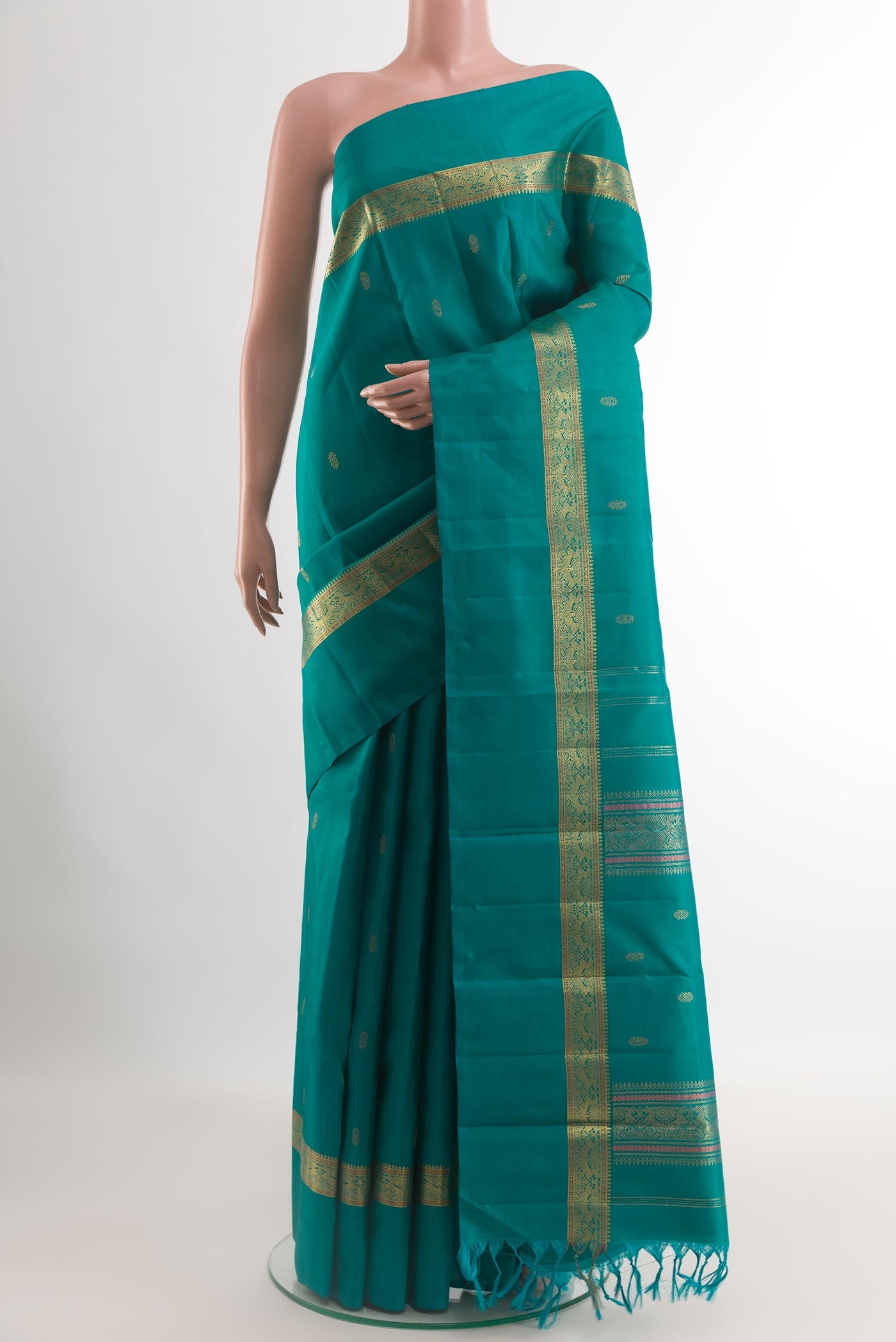 Peacock Blue Kanchipuram Silk Saree with Zari Butta on the body and Zari Border.  displayed on a mannequin