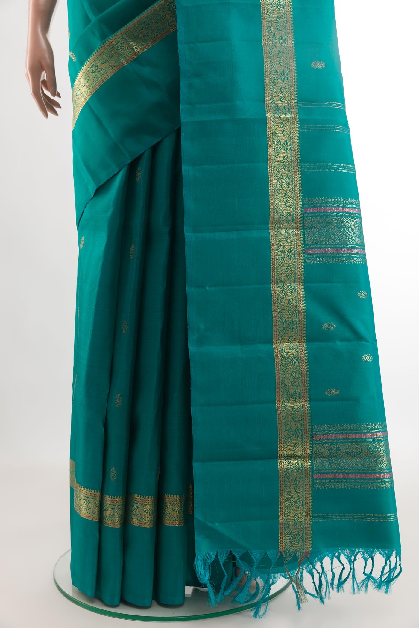 Pleats and pallu of Peacock Blue Kanchipuram Silk Saree with Zari Butta on the body and Zari Border. 