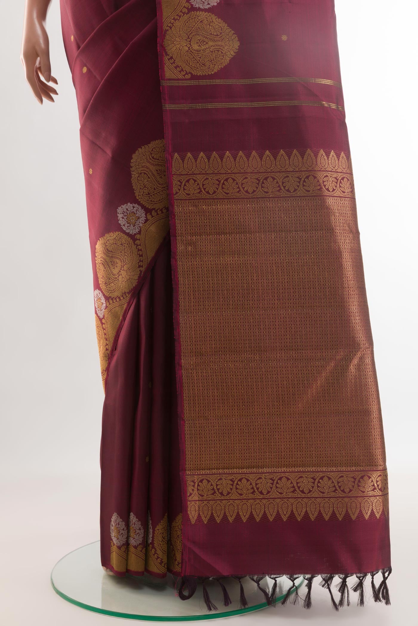 Pleats and pallu of Maroon Kanchipuram Silk Saree with Zari Butta on the body and Zari Border. 