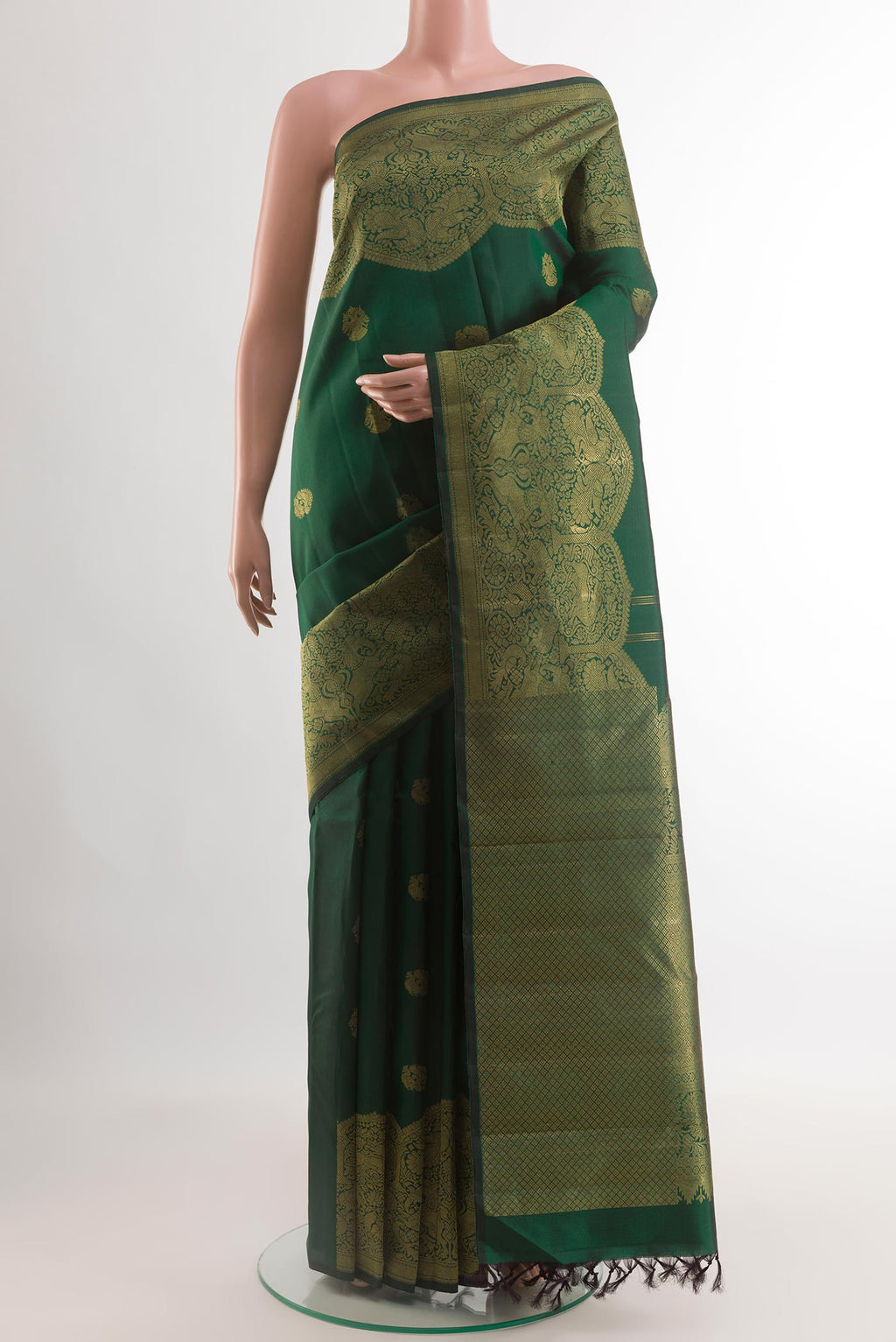 Bottle Green Kanchipuram Silk Saree with Zari Butta on the body and Fancy Border.  displayed on a mannequin