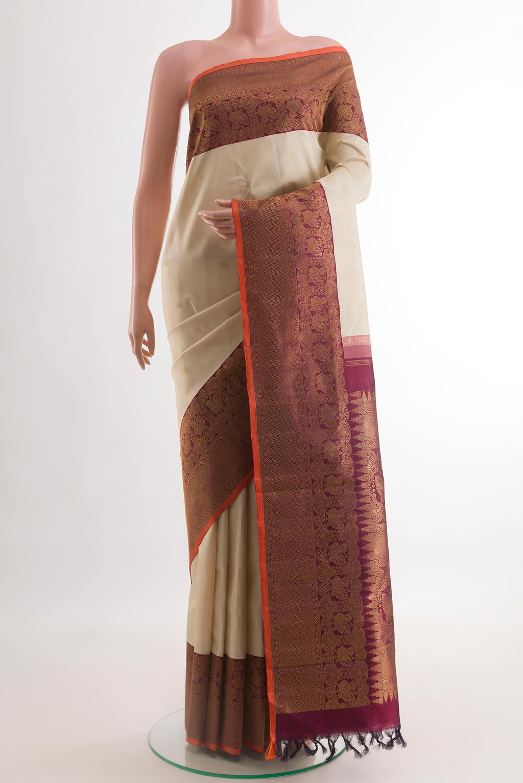 Off White Kanchipuram Silk Saree with Zari Butta on the body and Zari Border.  displayed on a mannequin