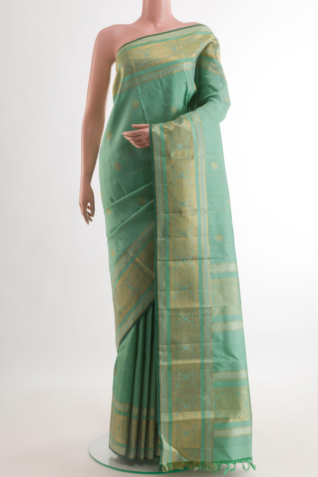 Light Green Kanjivaram Silk Saree with Zari Butta on the body and Zari Border.  displayed on a mannequin