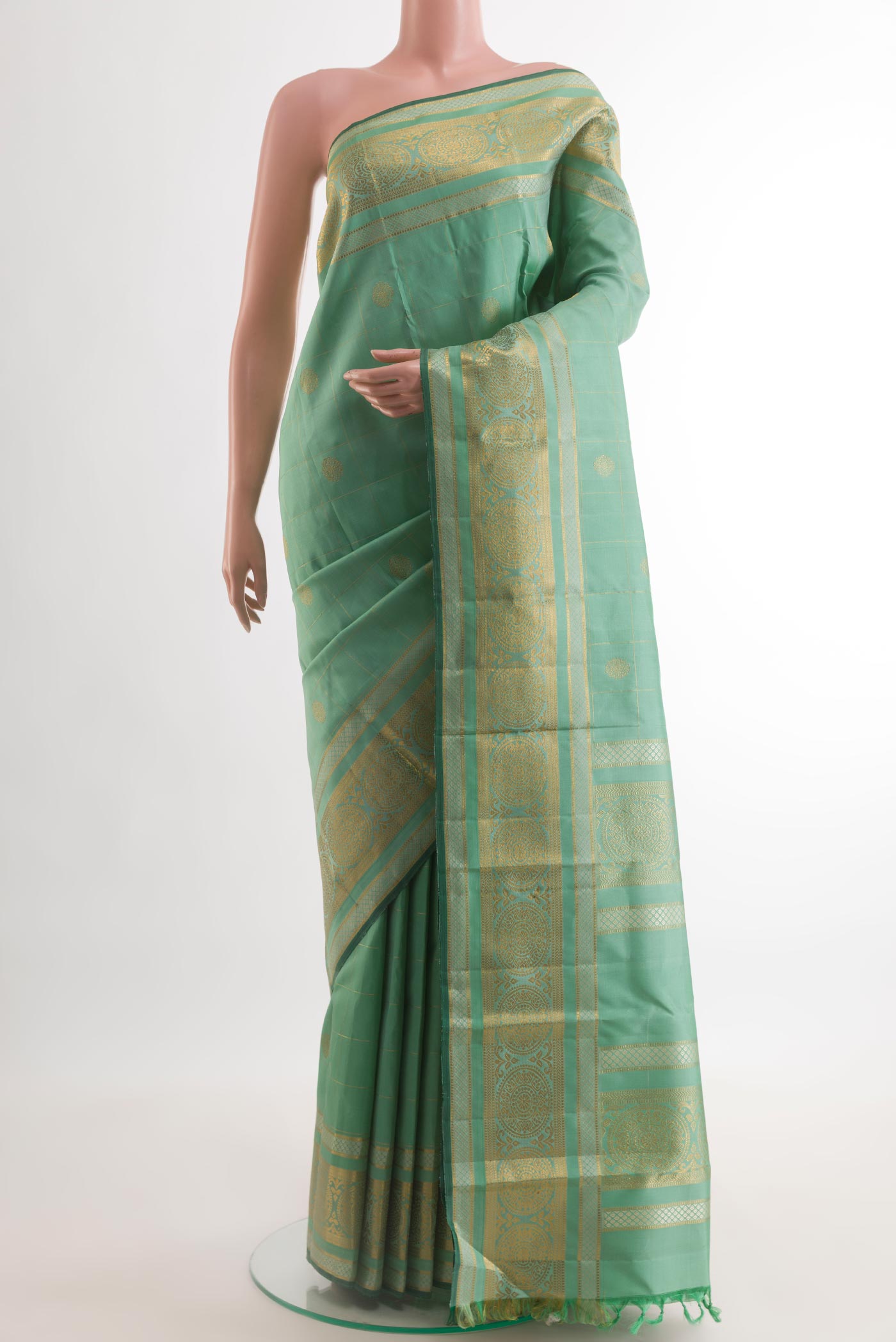 Light Green Kanjivaram Silk Saree with Zari Butta on the body and Zari Border.  displayed on a mannequin