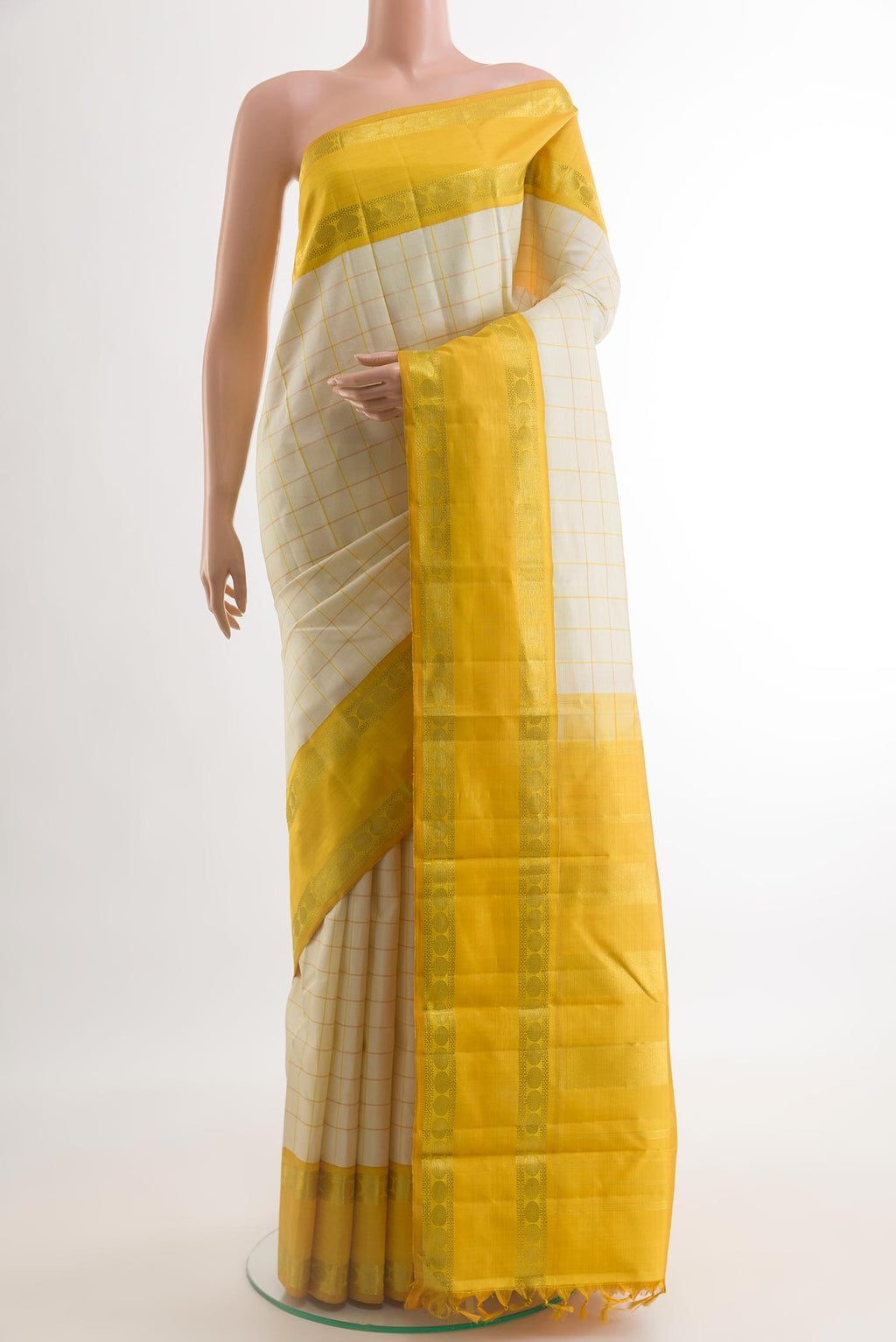 Off White Kanjivaram Silk Saree with Checked design on the body and Zari Border.  displayed on a mannequin