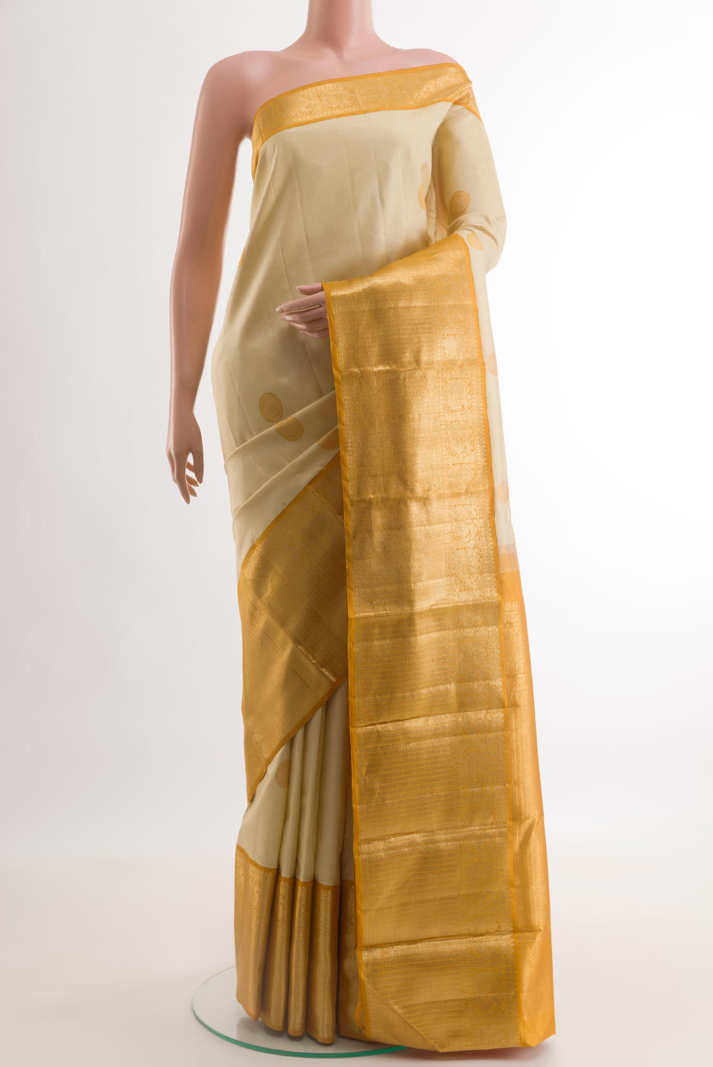 Cream Kanjivaram Silk Saree with Thread Butta on the body and Zari Border.  displayed on a mannequin