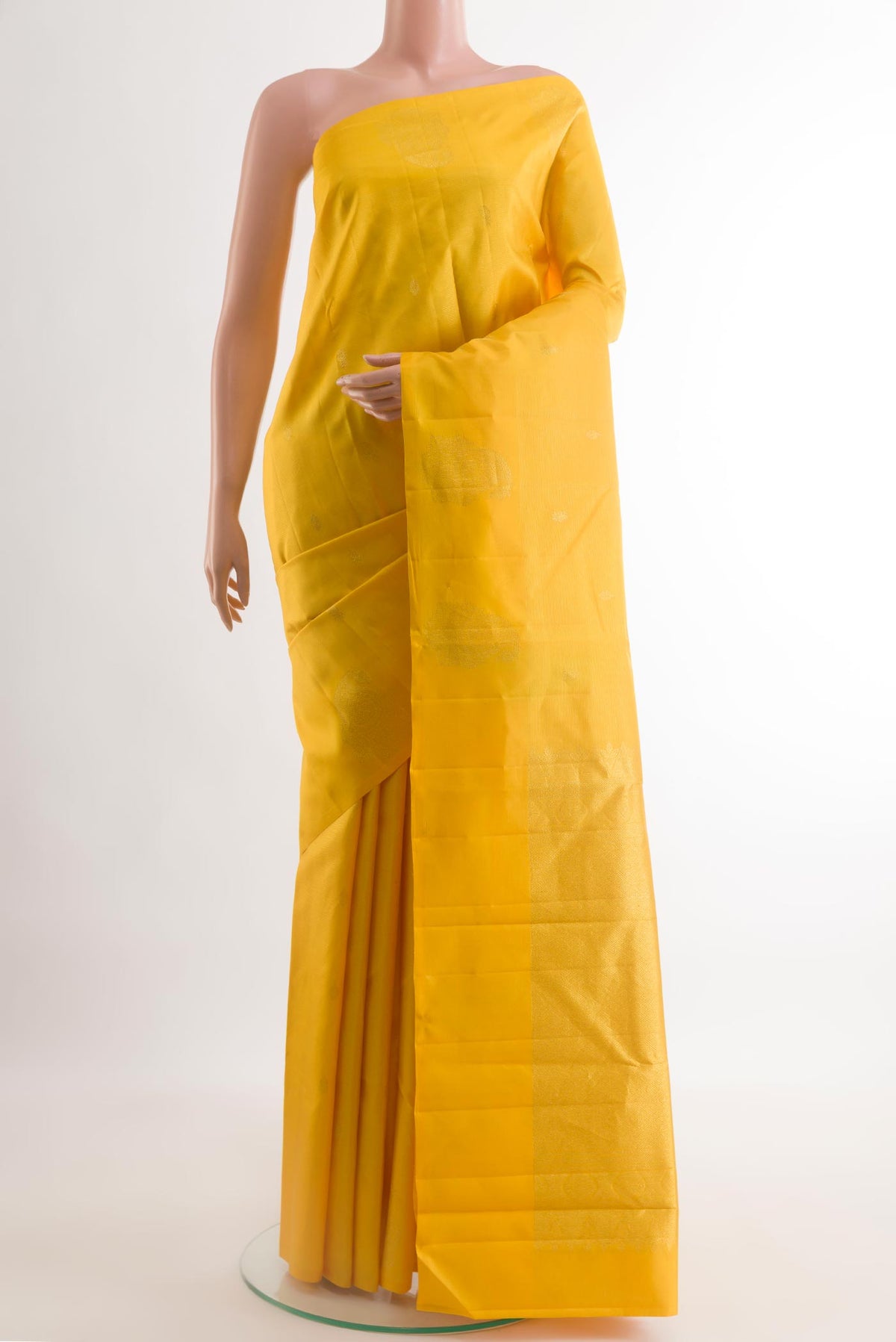 Yellow Kanchipuram Silk Saree with Zari Butta on the body and Zari Border.  displayed on a mannequin