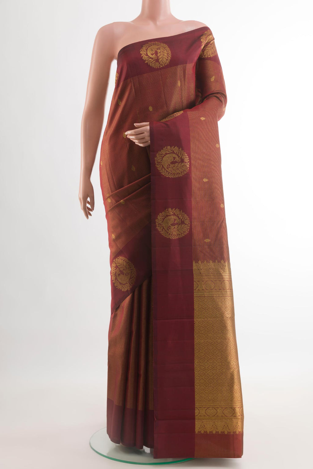 Maroon Kanchipuram Silk Saree with Zari Butta on the body and Zari Border.  displayed on a mannequin