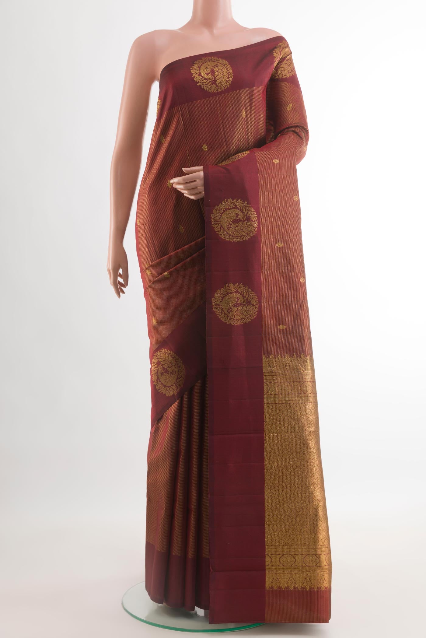 Maroon Kanchipuram Silk Saree with Zari Butta on the body and Zari Border.  displayed on a mannequin