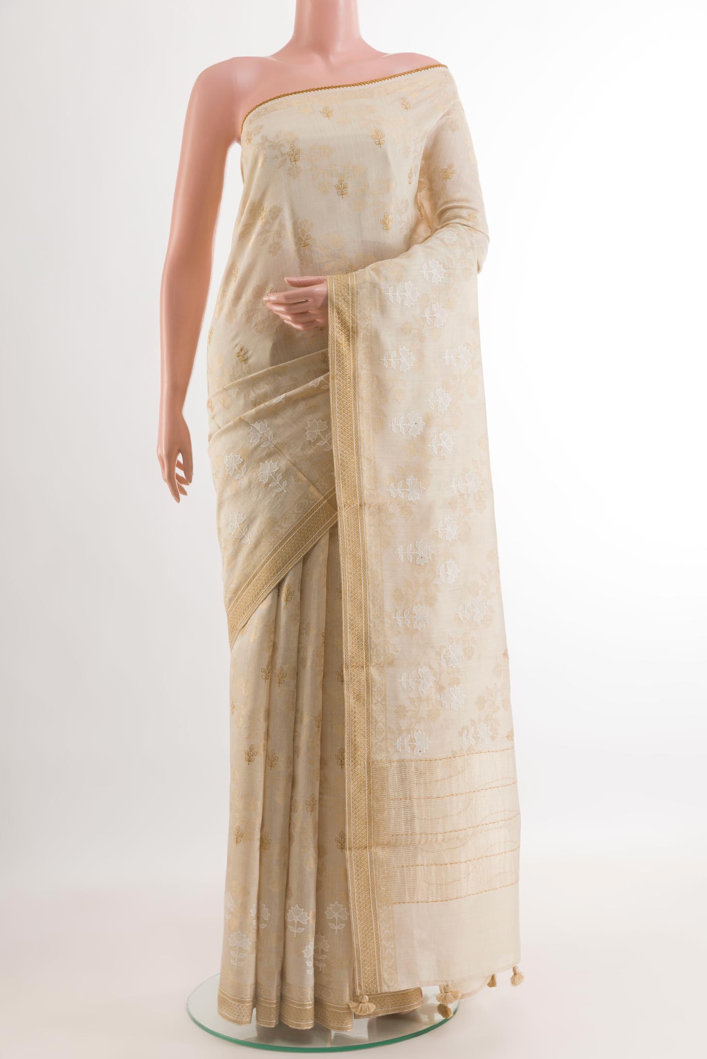 Cream Tussar Silk Saree with Embroidery on the body and Zari Border.  displayed on a mannequin