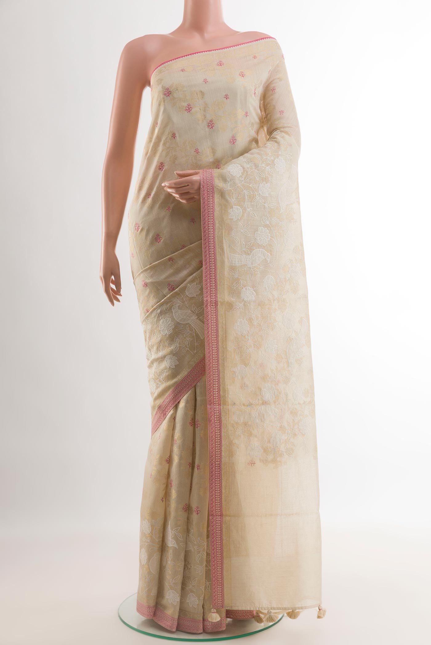 Cream Tussar Silk Saree with Embroidery on the body and Zari Border.  displayed on a mannequin