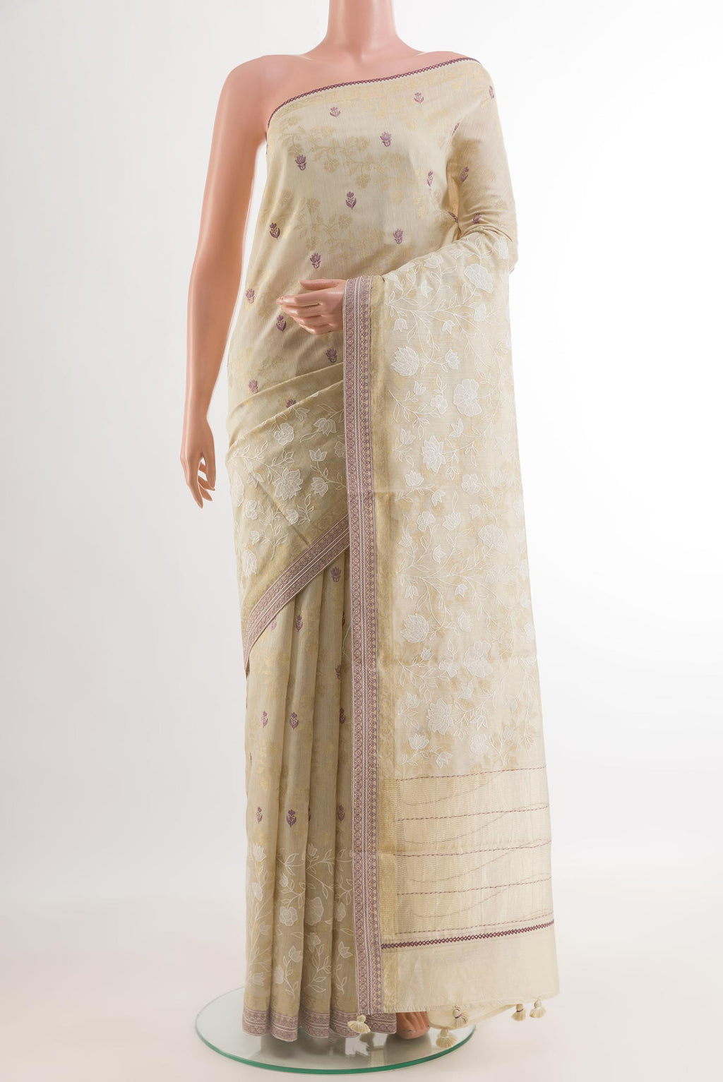 Cream Tussar Silk Saree with Embroidery on the body and Zari Border.  displayed on a mannequin