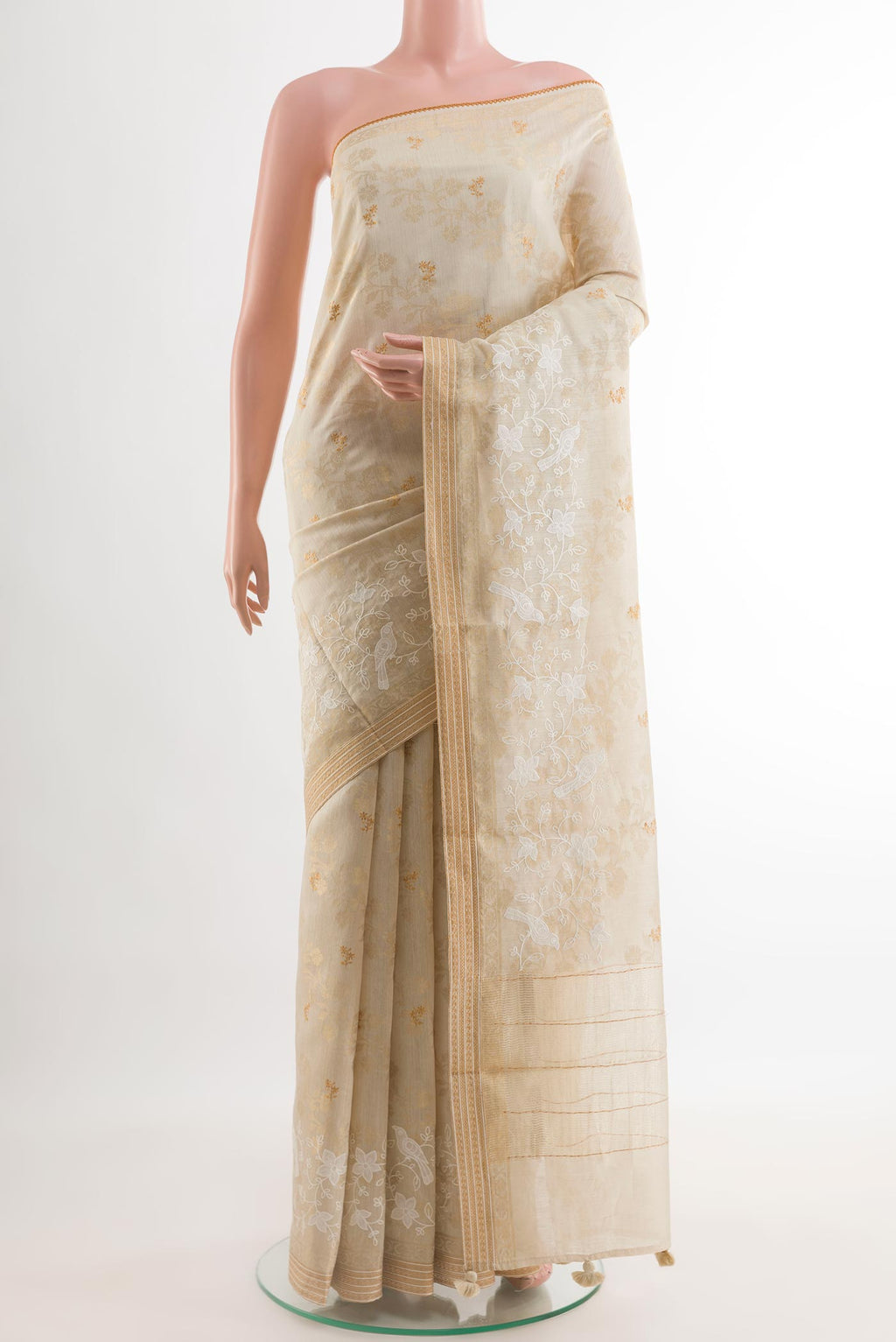 Cream Tussar Silk Saree with Embroidery on the body and Zari Border.  displayed on a mannequin