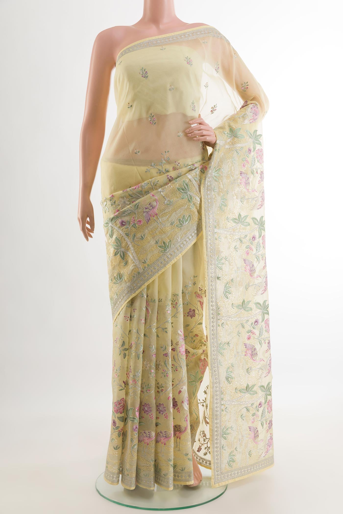 Lemon Yellow Organza Silk Saree with Embroidery on the body and Embroidery Border.  displayed on a mannequin