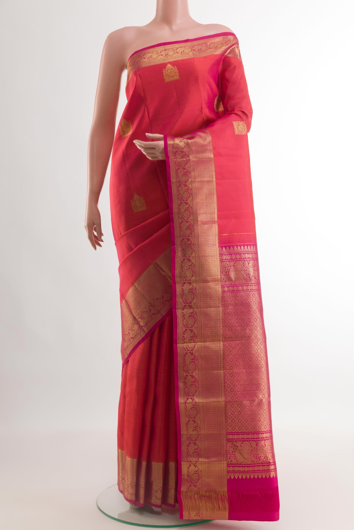 Coral Dual Tone Kanchipuram Silk Saree with Zari Butta on the body and Zari Border.  displayed on a mannequin