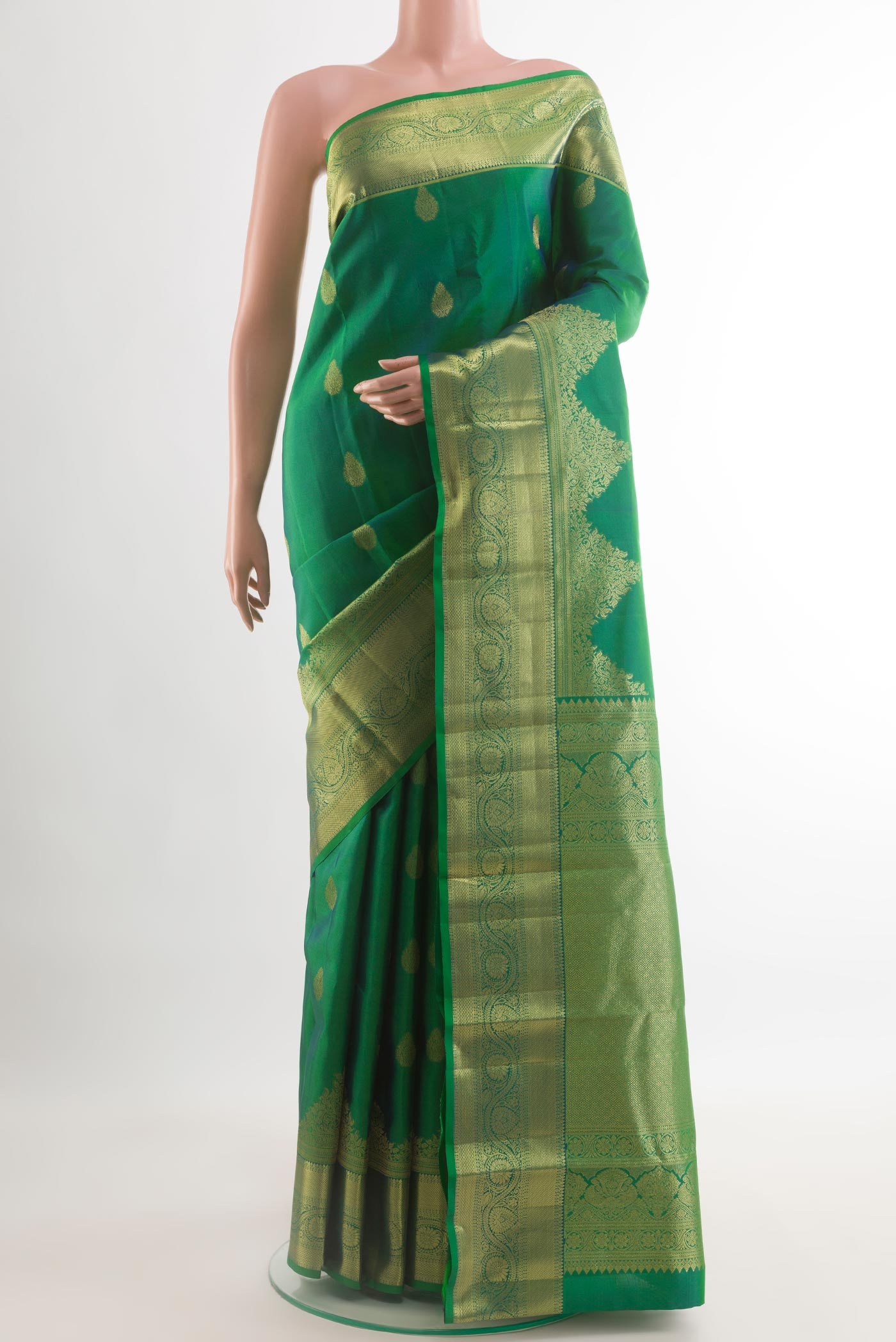 Green Kanchipuram Silk Saree with Zari Butta on the body and Zari Border.  displayed on a mannequin