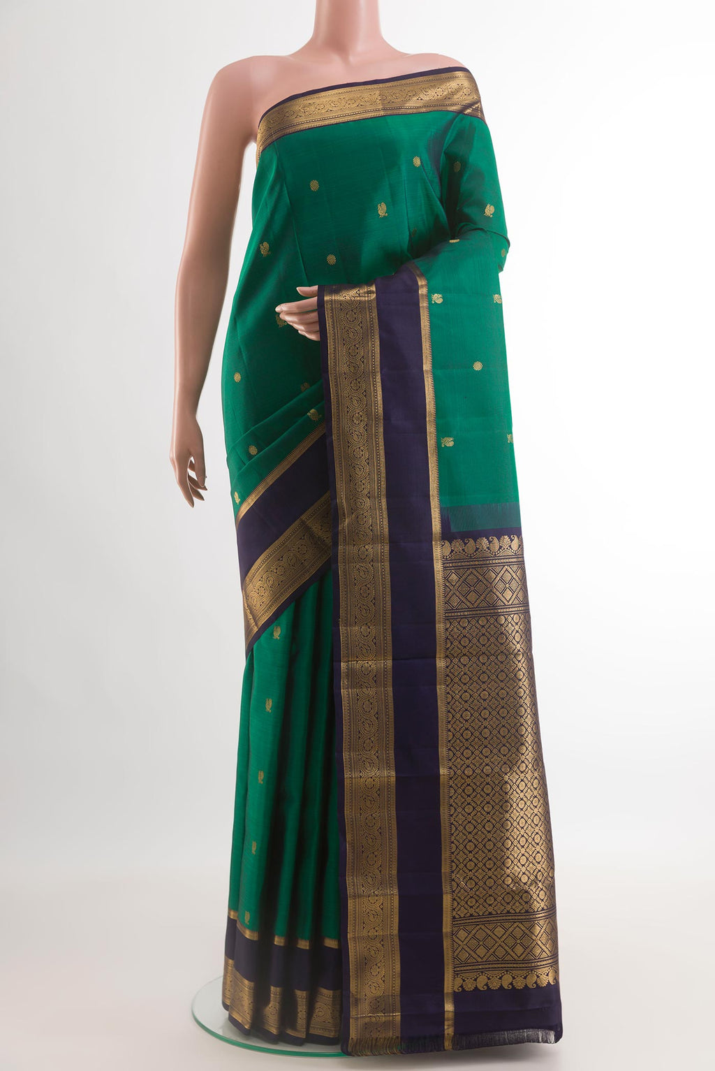 Green Kanchipuram Silk Saree with Zari Butta on the body and Zari Border.  displayed on a mannequin