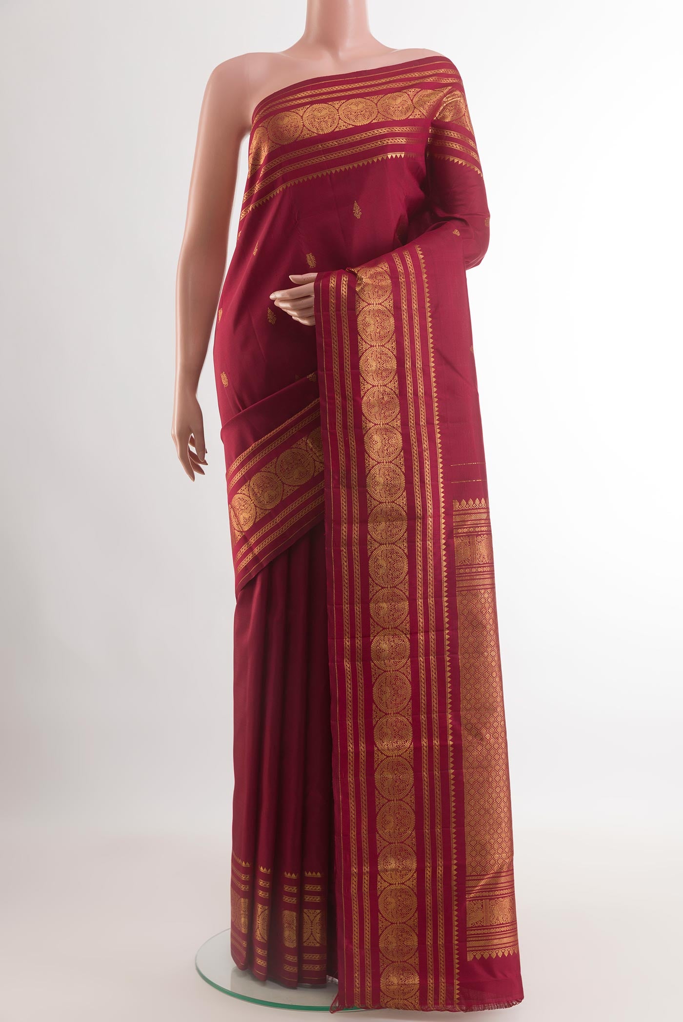 Maroon Kanjivaram Silk Saree with Zari Butta on the body and Zari Border.  displayed on a mannequin