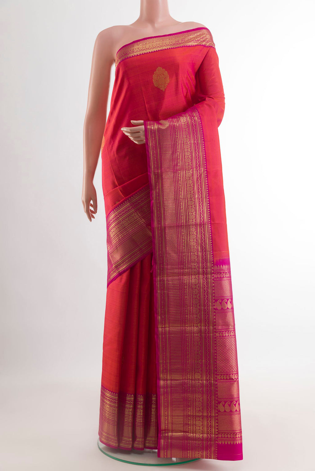 Brick Orange Dual Tone Kanchipuram Silk Saree with Zari Butta on the body and Zari Border.  displayed on a mannequin