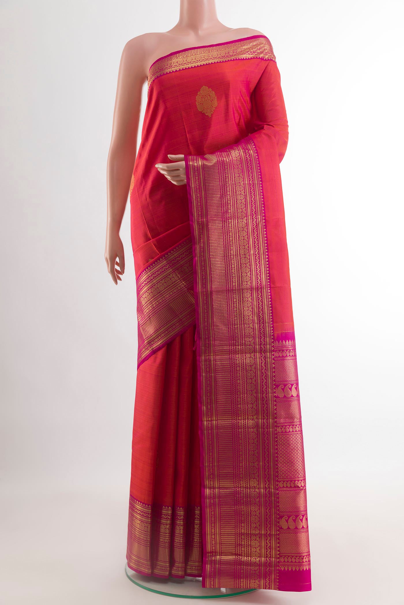 Brick Orange Dual Tone Kanchipuram Silk Saree with Zari Butta on the body and Zari Border.  displayed on a mannequin