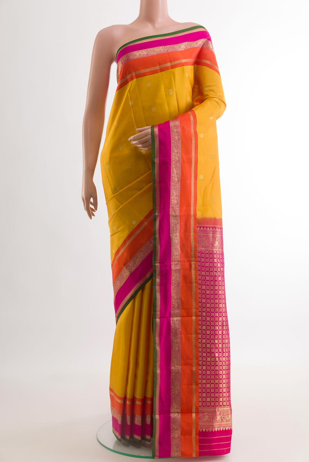 Mustard Kanchipuram Silk Saree with Zari Butta on the body and Zari Border.  displayed on a mannequin