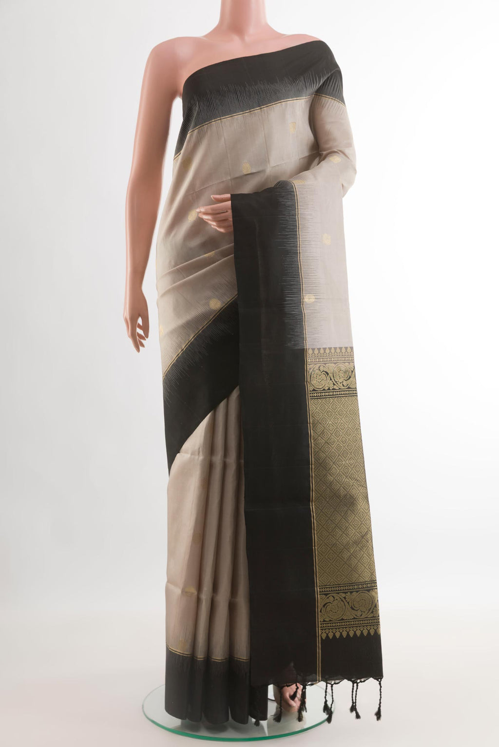 Off White Soft Silk Saree with Zari Butta on the body and Zari Border.  displayed on a mannequin