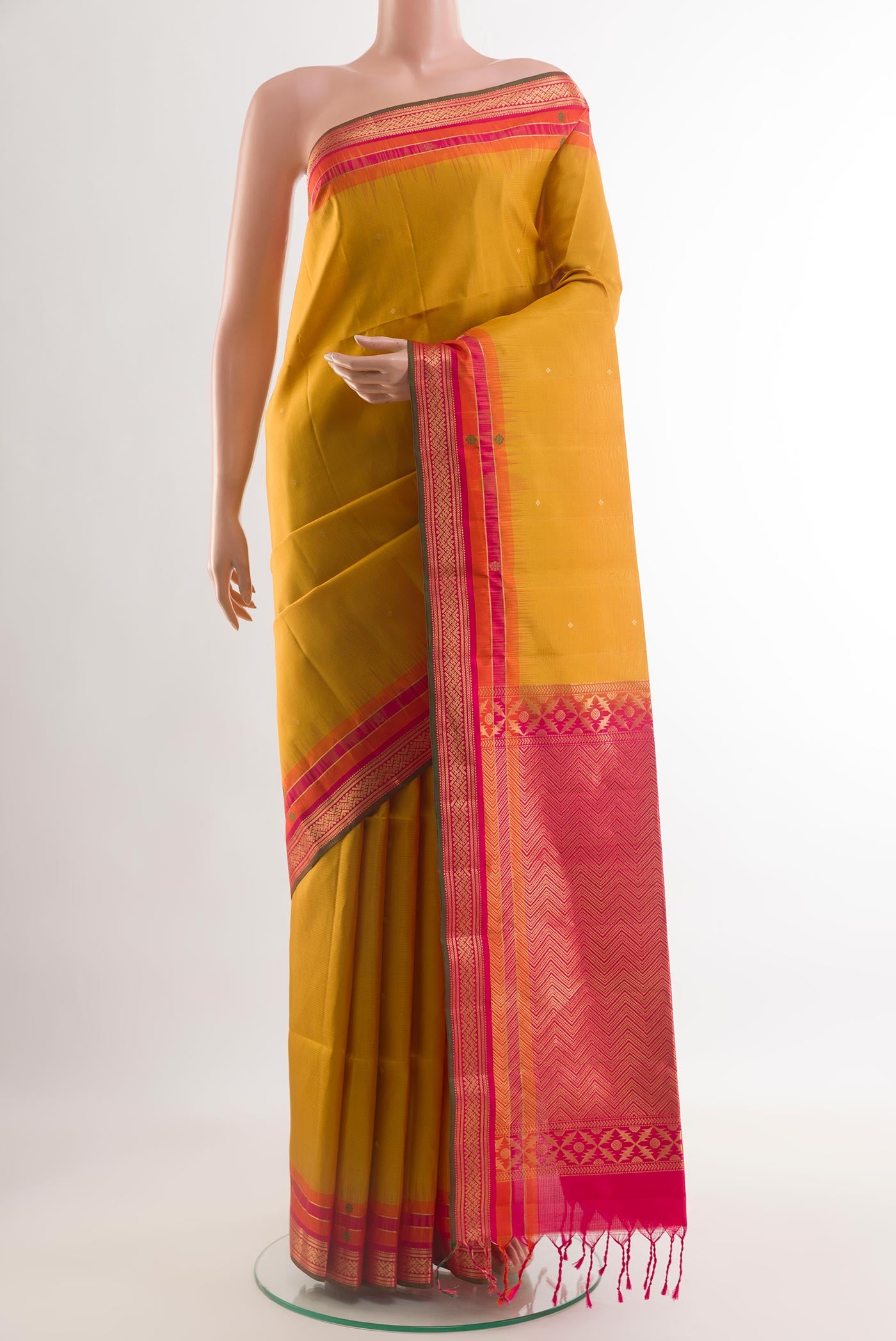 Mustard Soft Silk Saree with Zari Butta on the body and Zari Border.  displayed on a mannequin