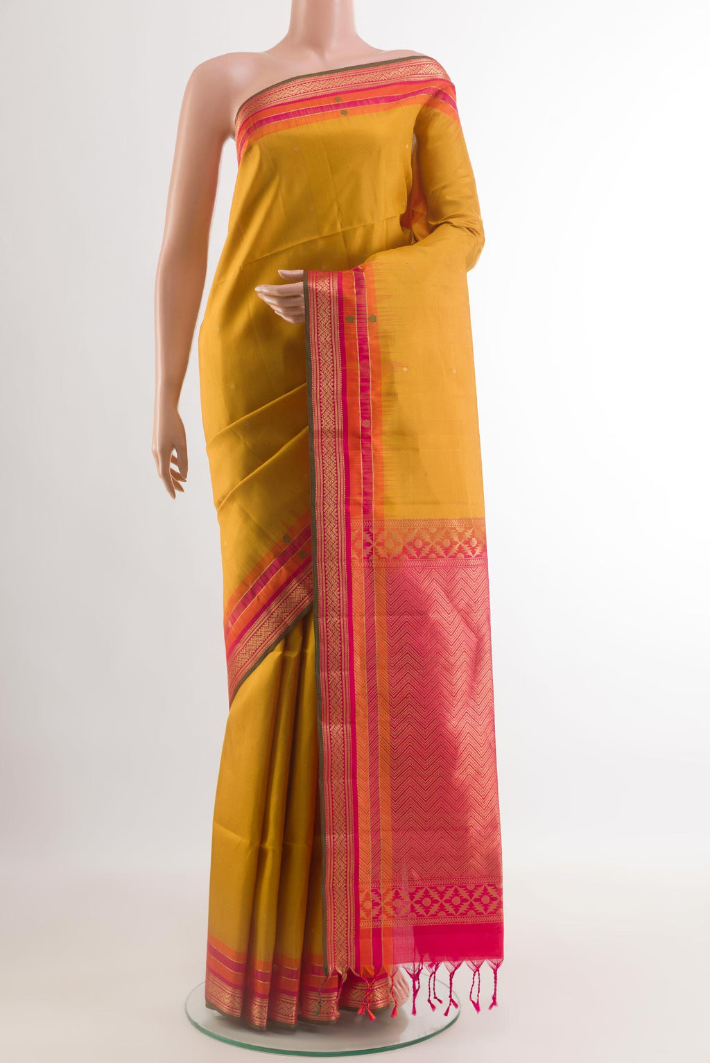 Mustard Soft Silk Saree with Zari Butta on the body and Zari Border.  displayed on a mannequin