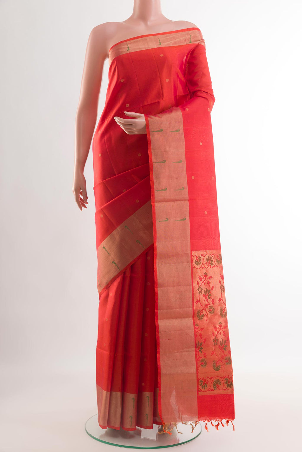 Brick Orange Soft Silk Saree with Zari Butta on the body and Zari Border.  displayed on a mannequin