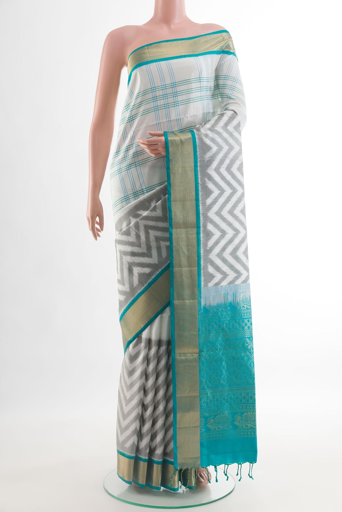 Off White Soft Silk Saree with Ikat design on the body and Zari Border.  displayed on a mannequin