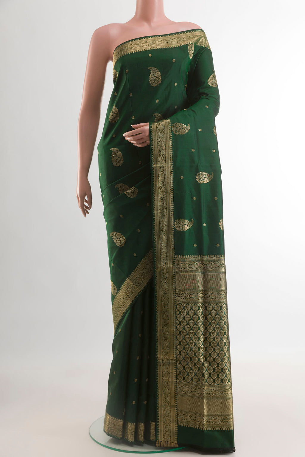 Bottle Green Soft Silk Saree with Zari Butta on the body and Zari Border.  displayed on a mannequin