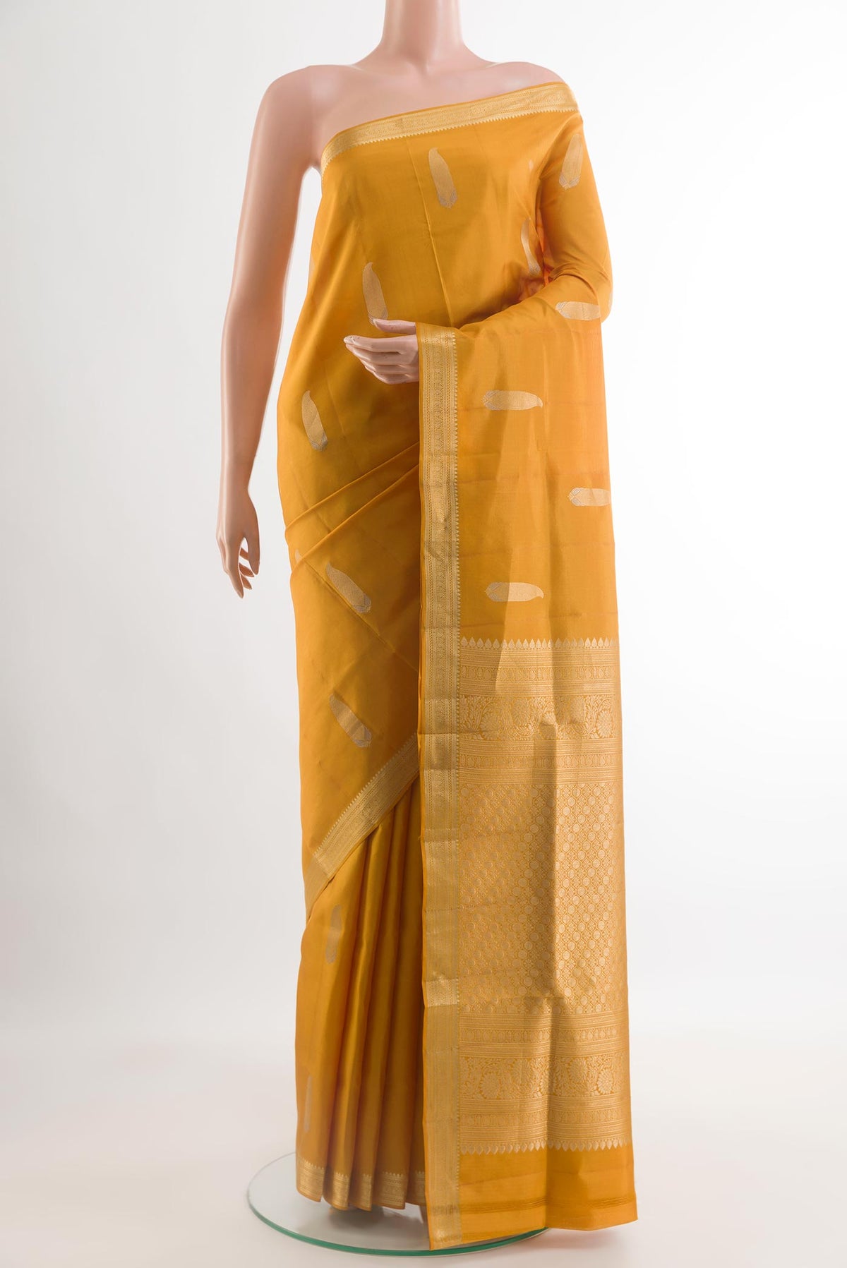 Mustard Soft Silk Saree with Zari Butta on the body and Zari Border.  displayed on a mannequin