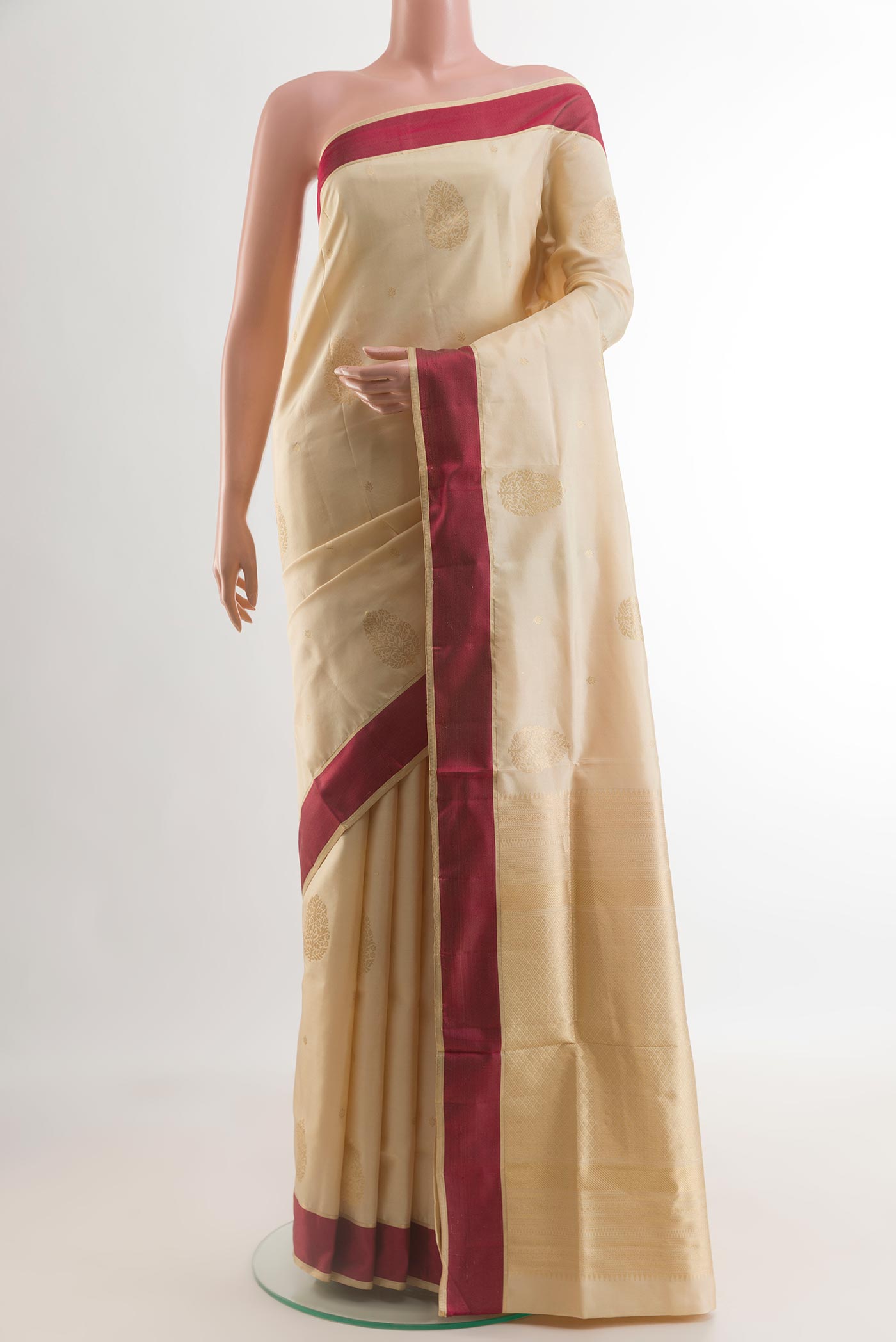 Cream Soft Silk Saree with Zari Butta on the body and Thread Border.  displayed on a mannequin