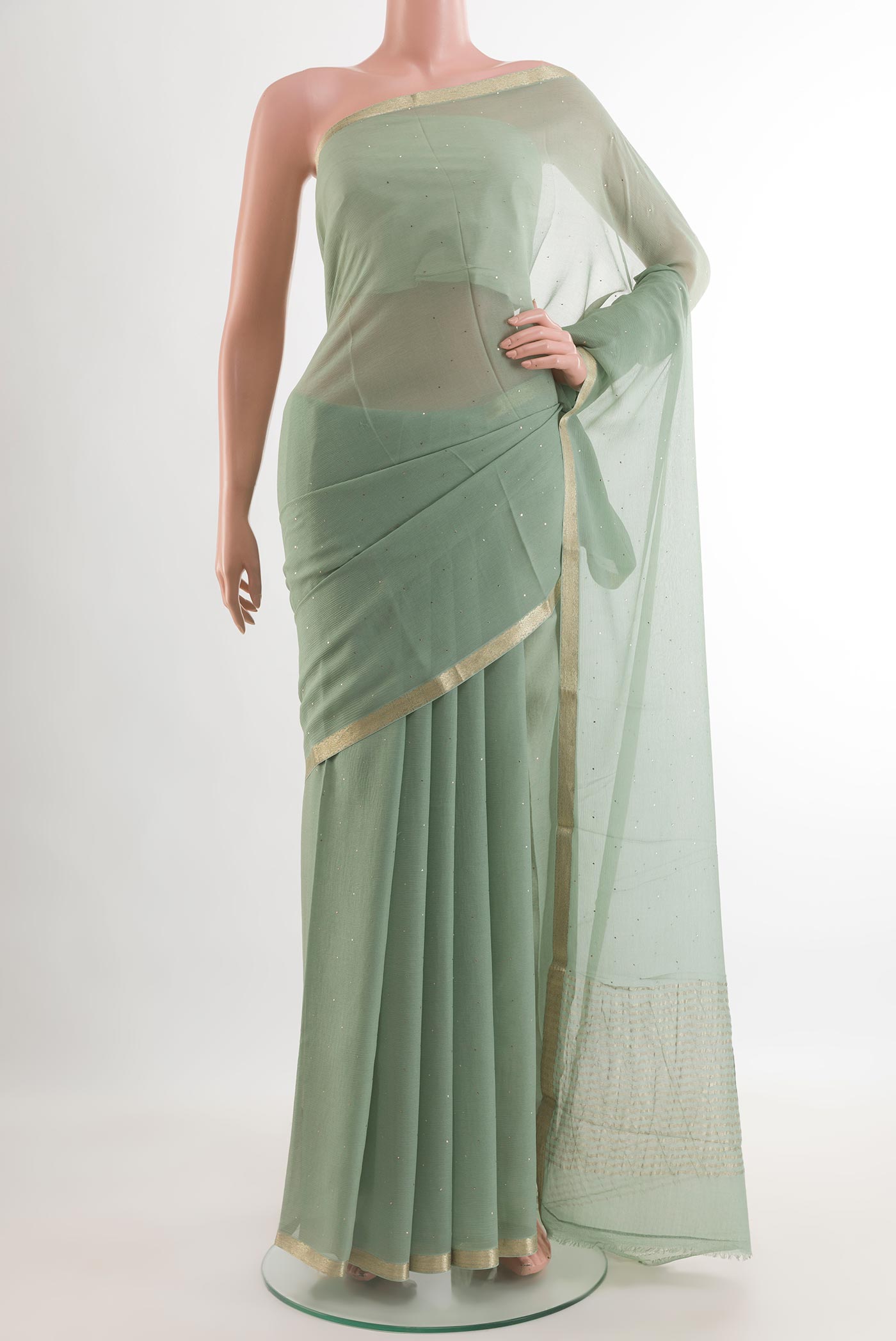 Sage Green Chiffon Saree with Embroidery on the body and Zari Border.  displayed on a mannequin