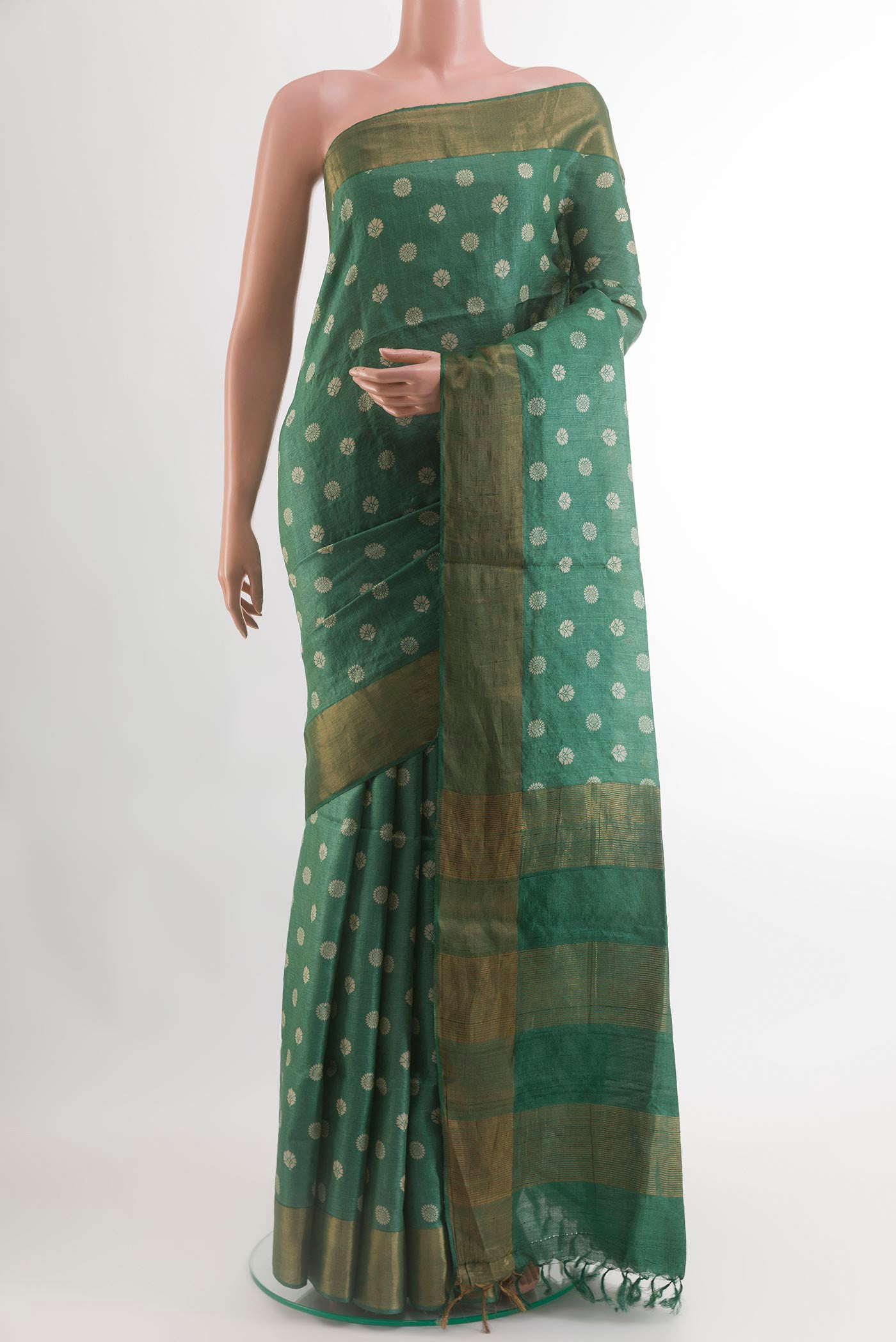 Green Tussar Silk Saree with Printed design on the body and Zari Border.  displayed on a mannequin