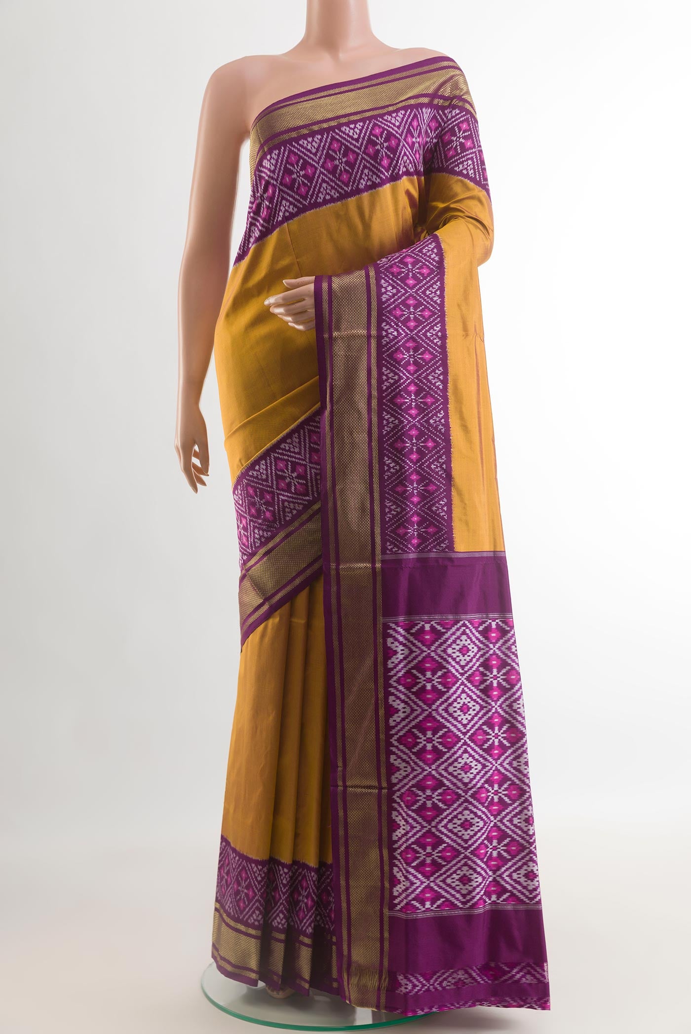 Mustard Pochampally Silk Saree with Plain Body and Ikat Border.  displayed on a mannequin