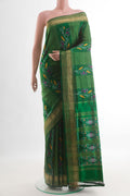 Green Pochampally Silk Saree with Ikat design on the body and Zari Border.  displayed on a mannequin