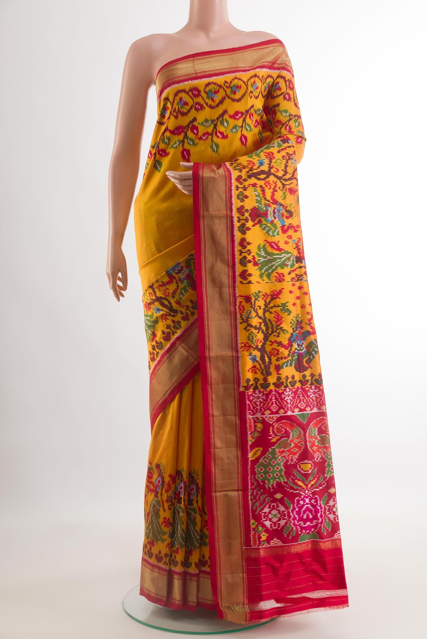 Mustard Pochampally Silk Saree with Plain Body and Ikat Border.  displayed on a mannequin