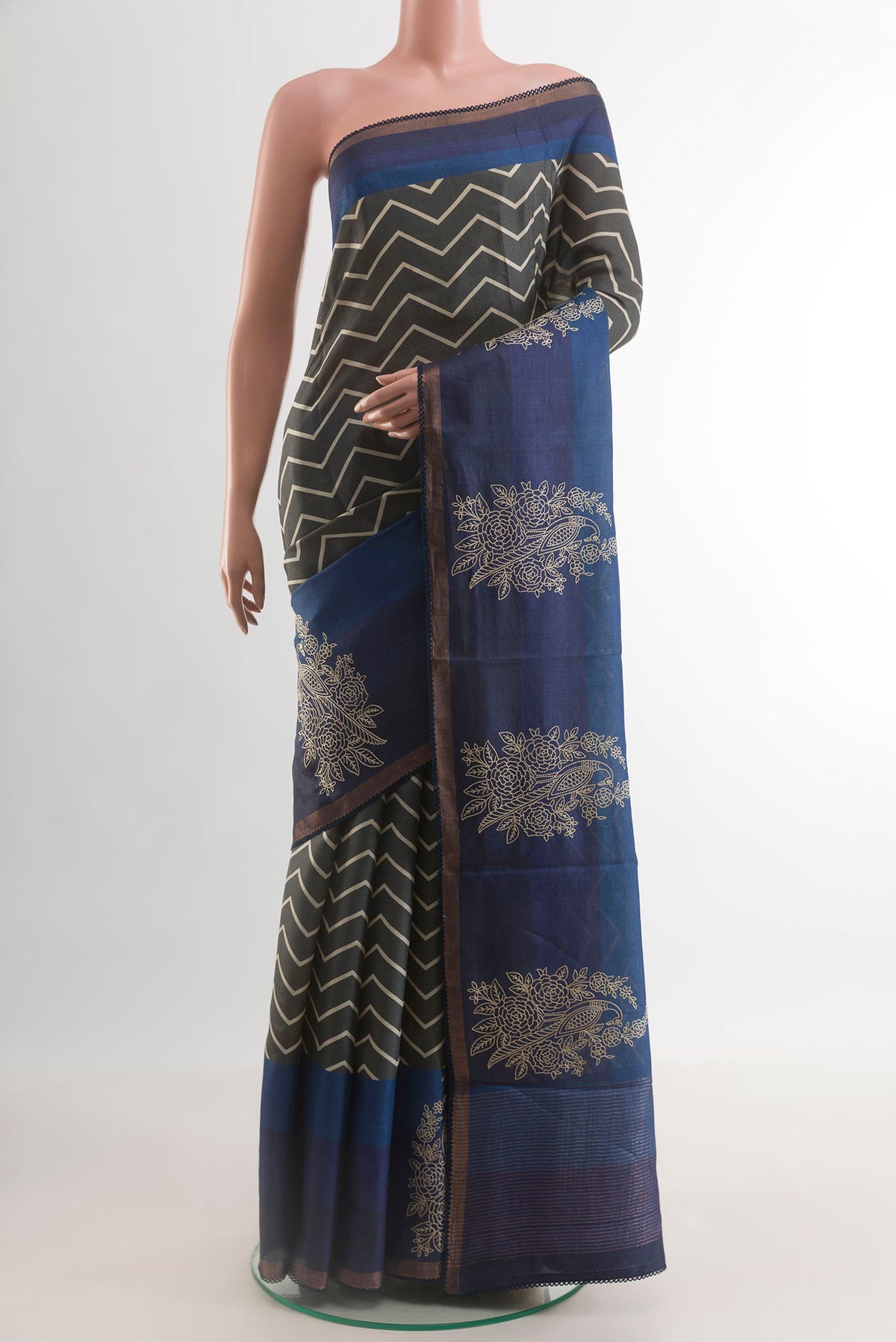 Grey Tussar Silk Saree with Printed design on the body and Zari Border.  displayed on a mannequin