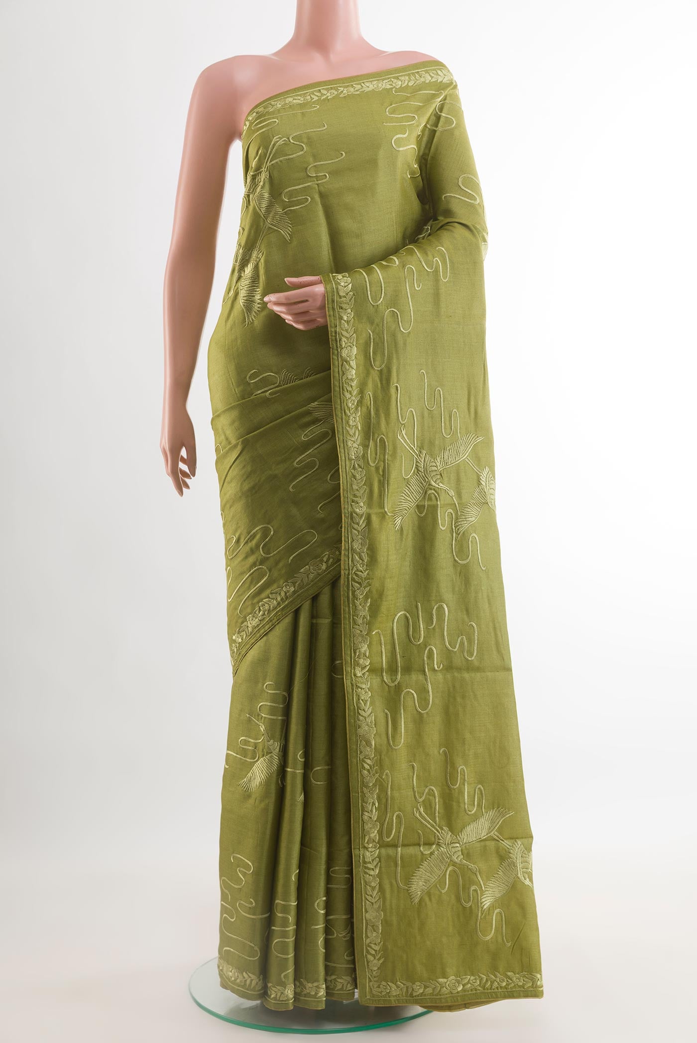 Green Tussar Silk Saree with Embroidery on the body and Embroidery Border.  displayed on a mannequin