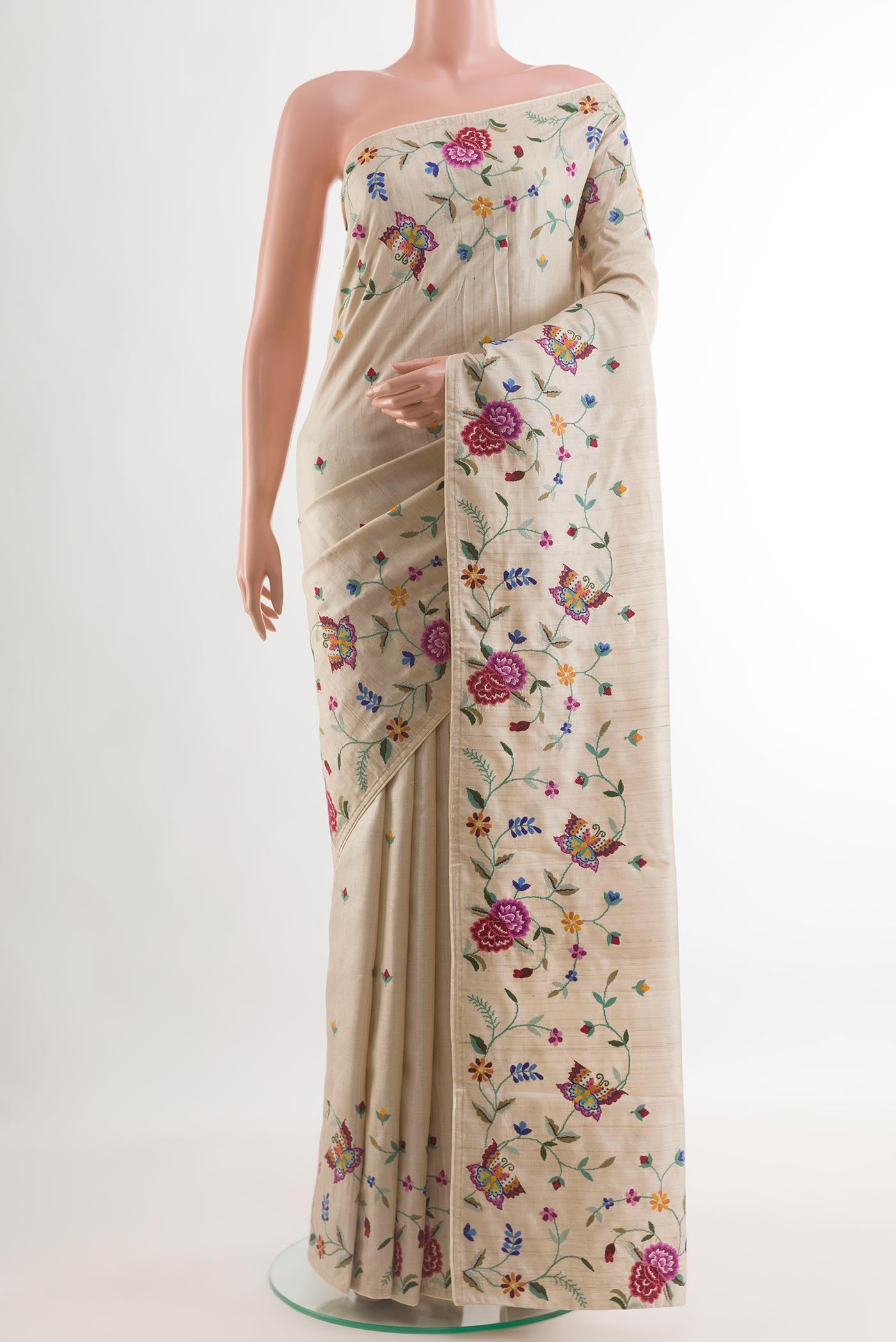 Cream Tussar Saree with Embroidery on the body and Embroidery Border.  displayed on a mannequin