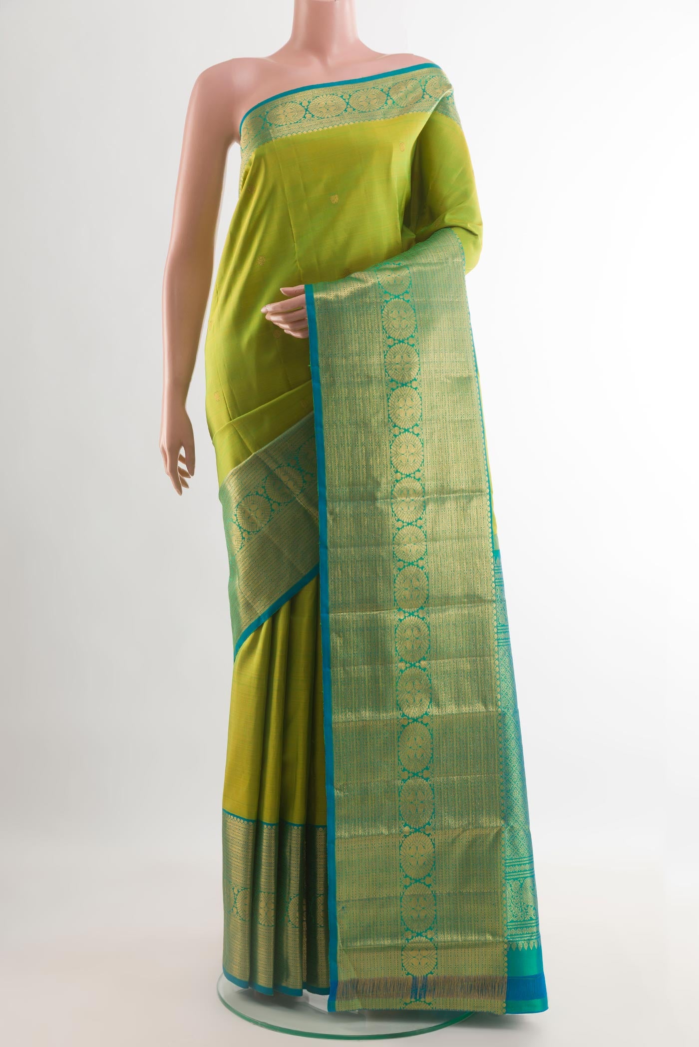 Green Kanchipuram Silk Saree with Zari Butta on the body and Zari Border.  displayed on a mannequin