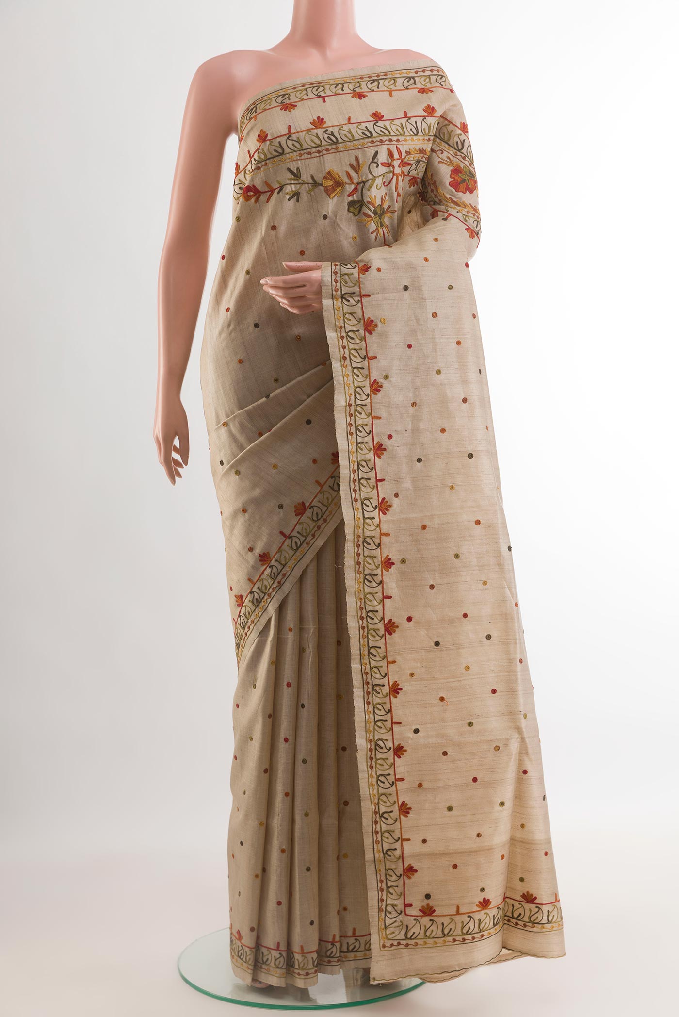 Beige Tussar Silk Saree with Embroidery on the body and Embroidery Border.  displayed on a mannequin