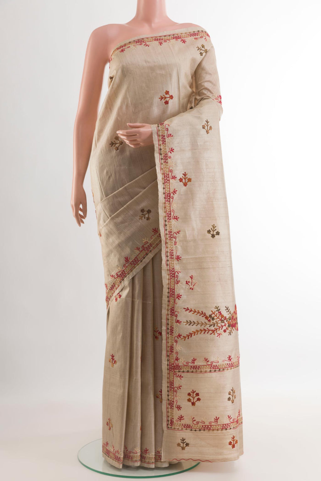 Beige Tussar Silk Saree with Embroidery on the body and Embroidery Border.  displayed on a mannequin