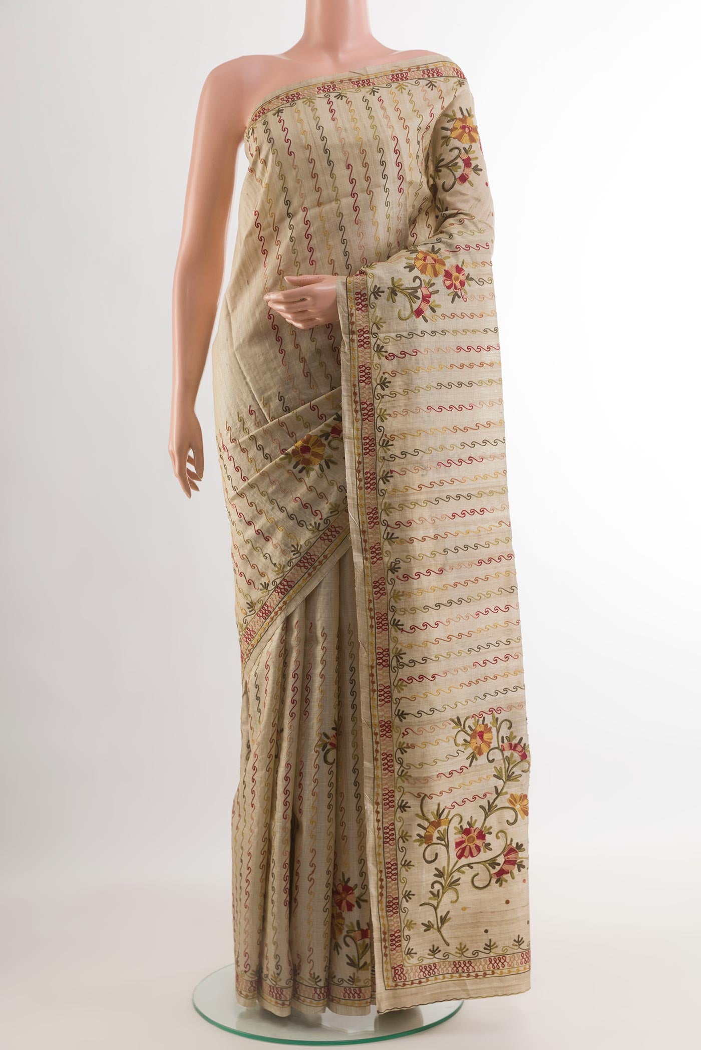 Beige Tussar Silk Saree with Embroidery on the body and Embroidery Border.  displayed on a mannequin