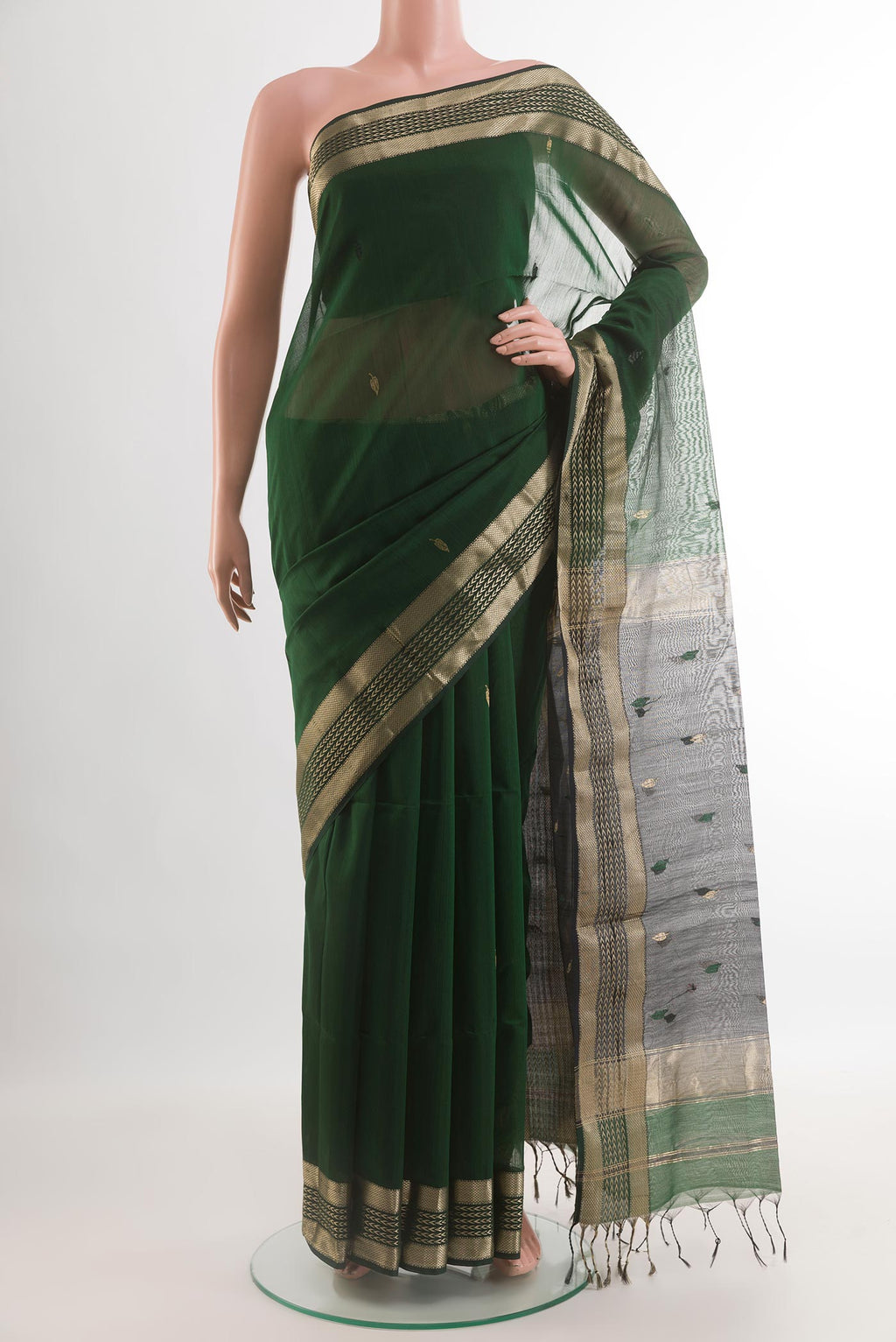 Bottle Green Maheshwari Silk Cotton Saree with Zari And Thread Butta on the body and Zari Border.  displayed on a mannequin