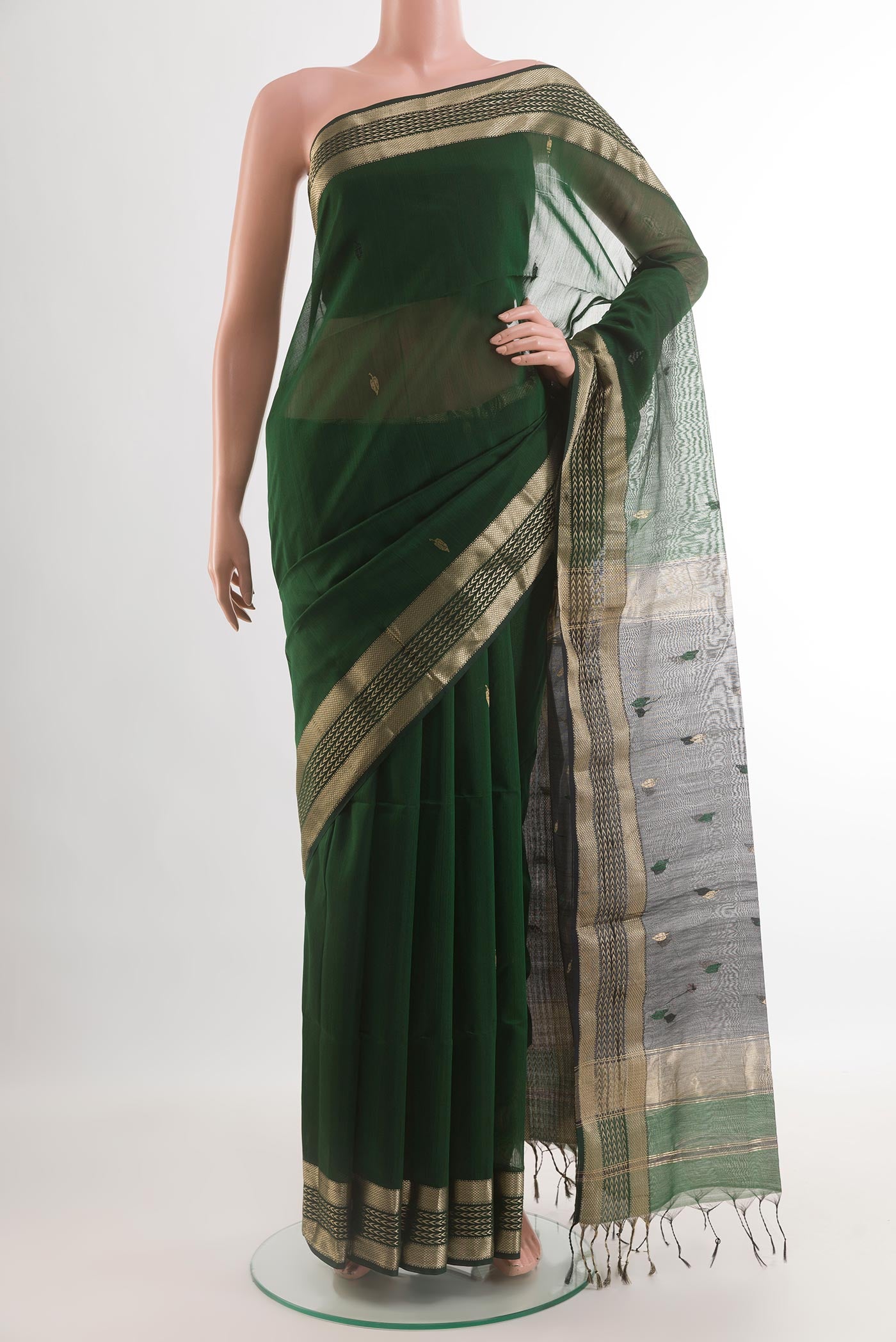 Bottle Green Maheshwari Silk Cotton Saree with Zari And Thread Butta on the body and Zari Border.  displayed on a mannequin