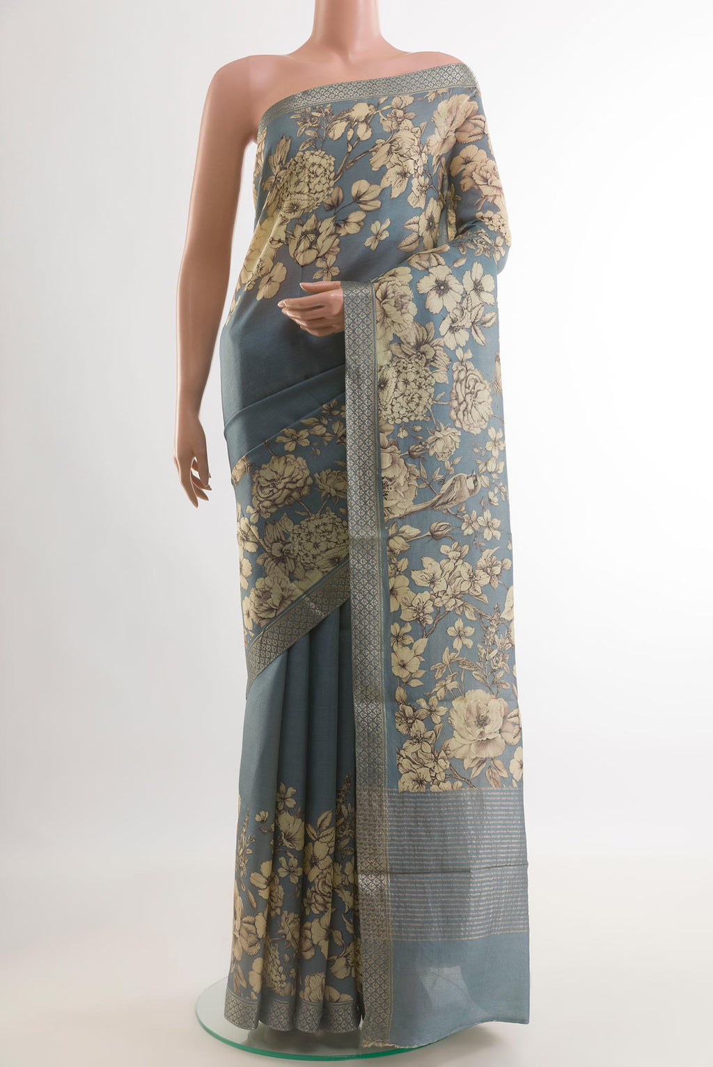 Grey Tussar Silk Saree with Printed design on the body and Zari Border.  displayed on a mannequin